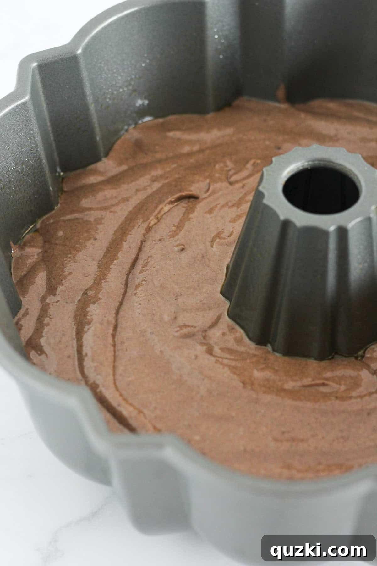 Decadent Texas Sheet Cake Bundt 5 The chocolate cake batter being carefully poured into a well-greased bundt pan, ready for the oven.