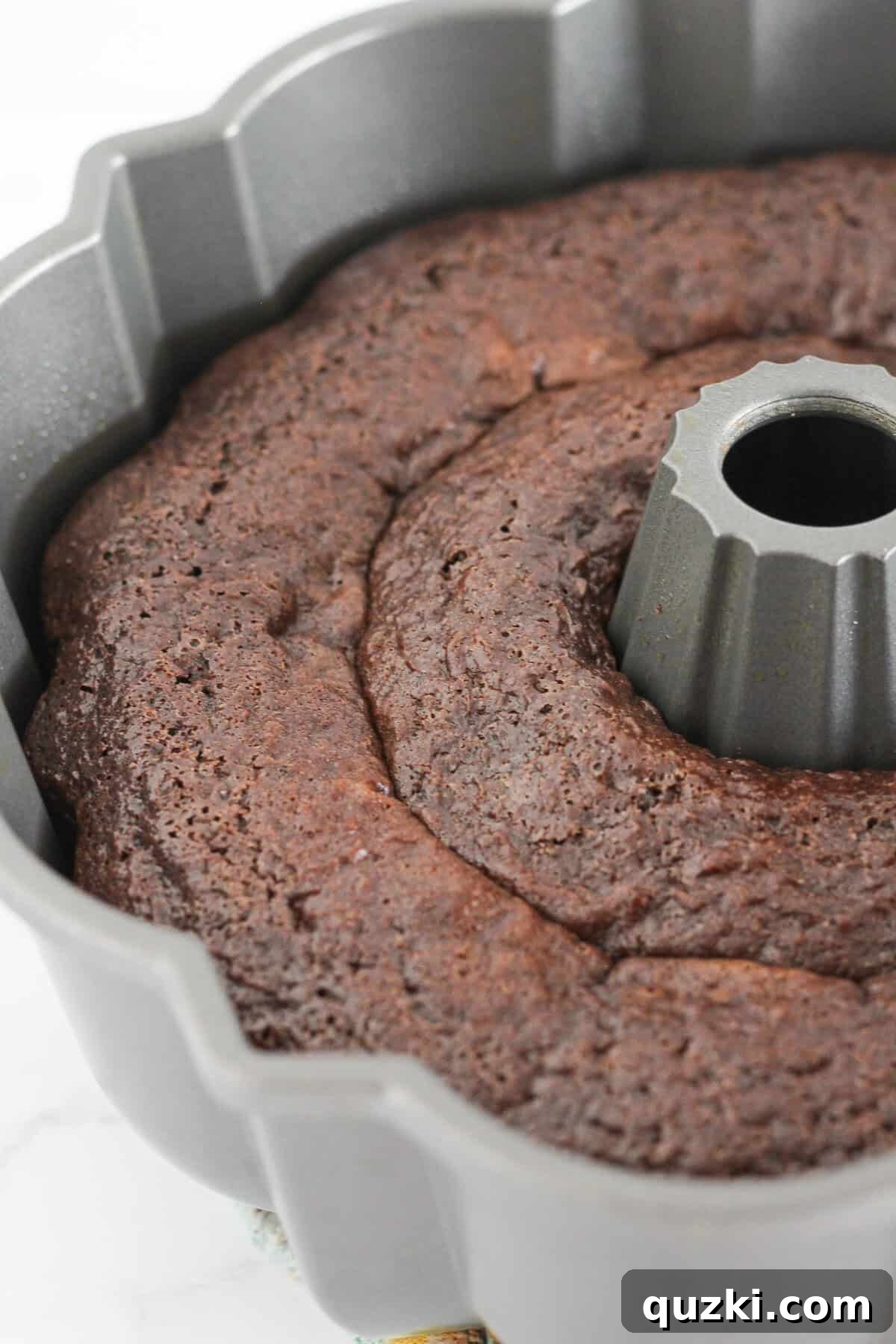 Decadent Texas Sheet Cake Bundt 6 A freshly baked Texas Bundt Cake cooling in the pan on a wire rack, ready to be inverted and frosted.