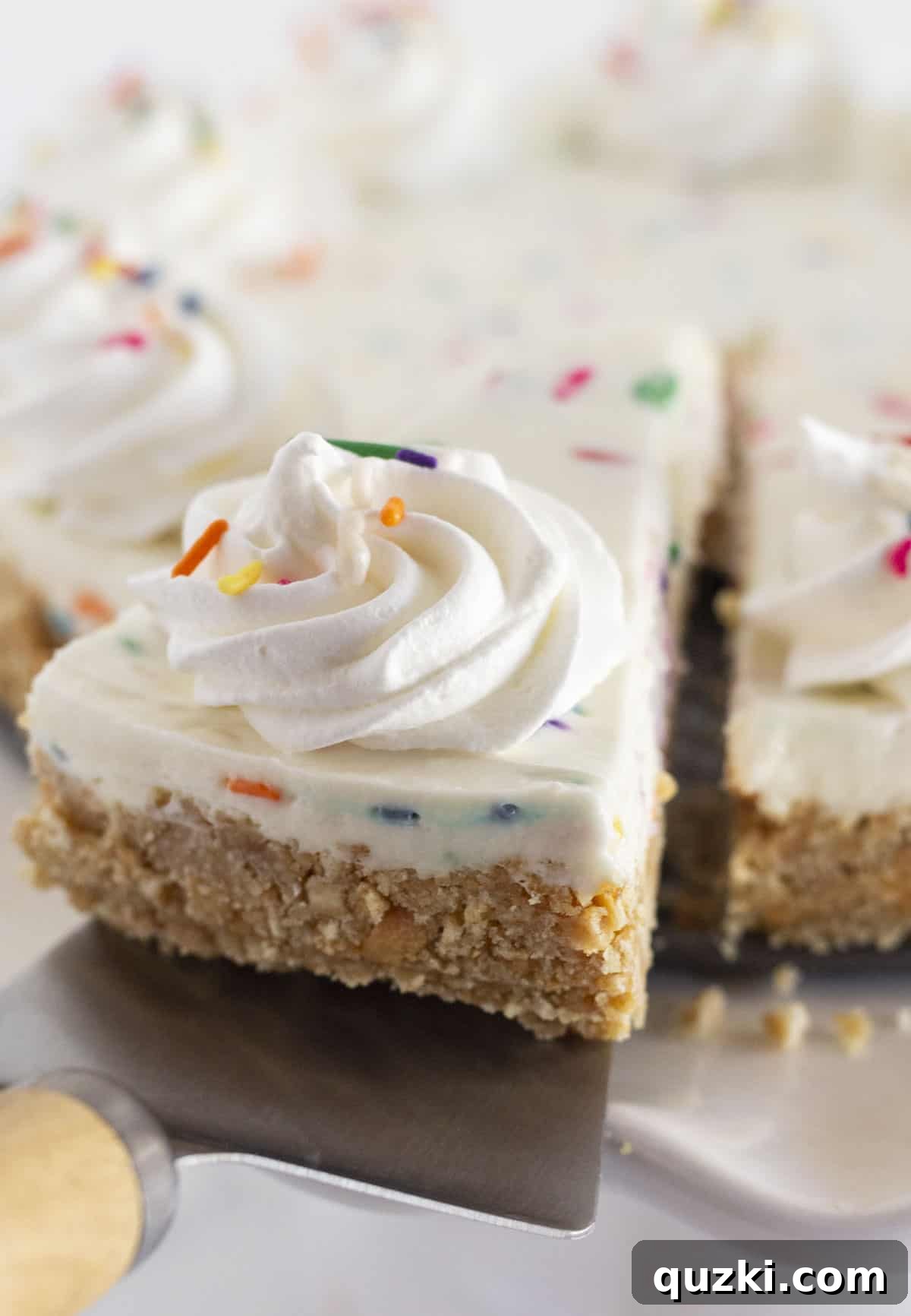 Effortless Funfetti Cheesecake Celebration 6 A perfectly portioned slice of funfetti no bake cheesecake, adorned with a delicate swirl of whipped cream and a scattering of colorful sprinkles, beautifully presented and ready to be savored.