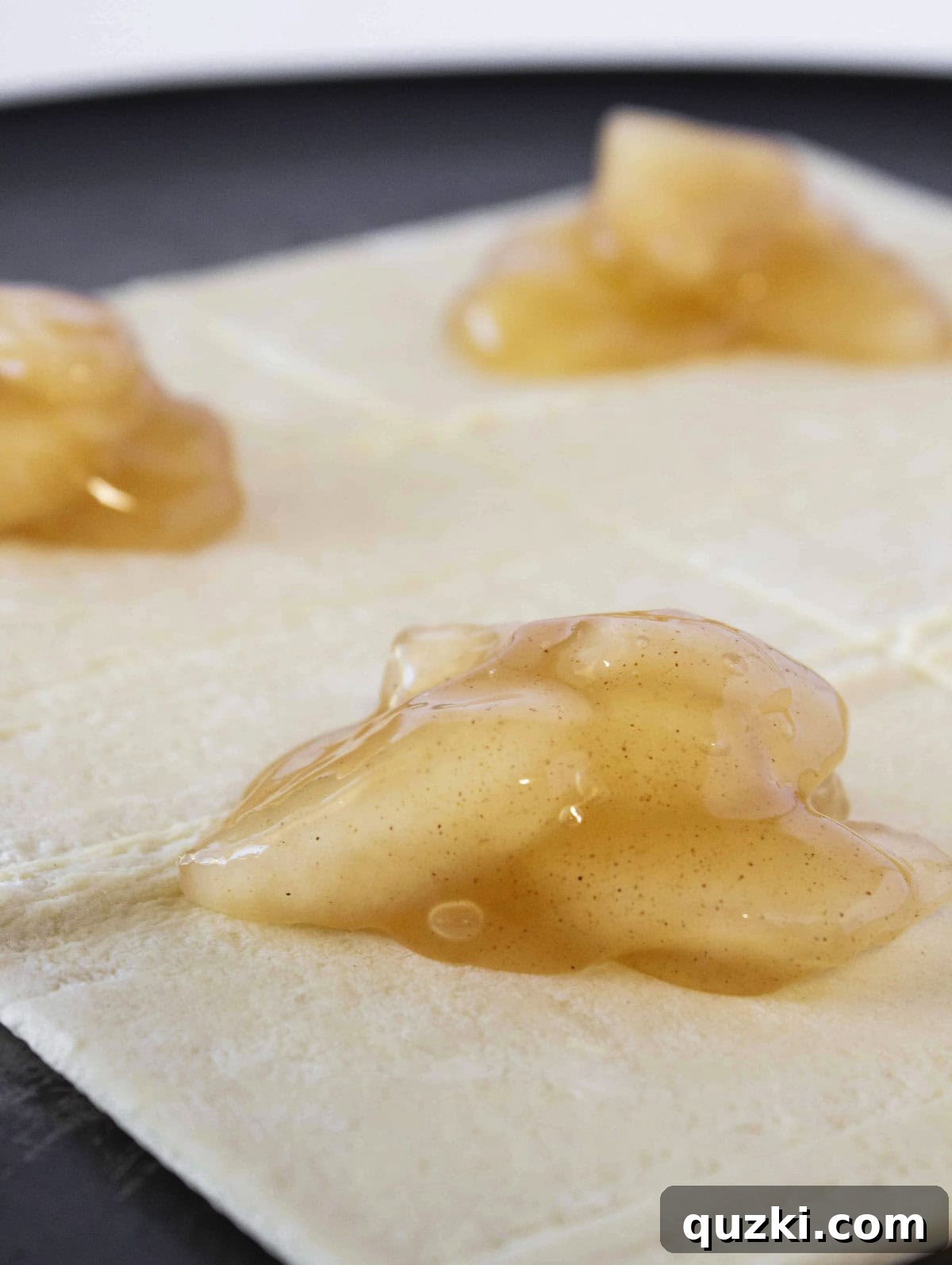Sweet & Simple Caramel Apple Turnovers 4 Adding a generous spoonful of sweet apple pie filling onto the center of a thawed puff pastry square, ready for folding.