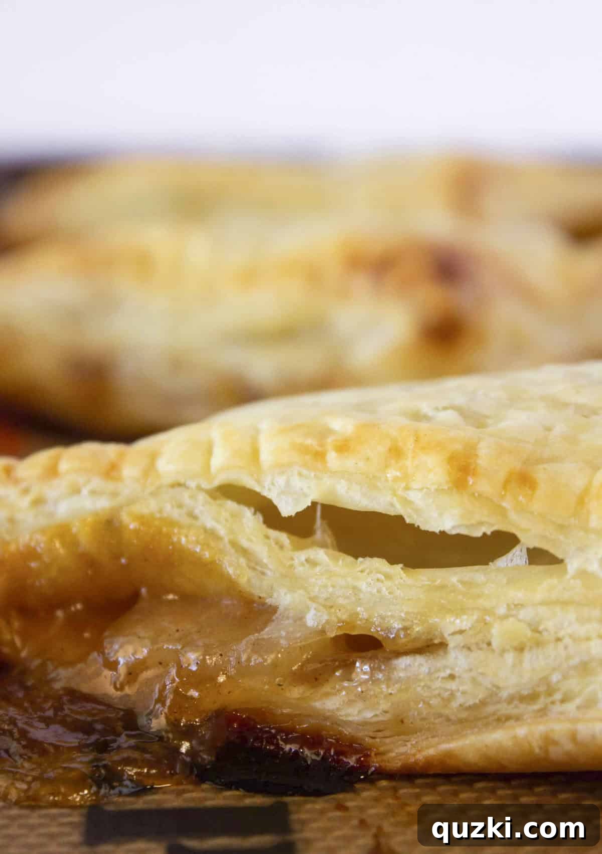 Sweet & Simple Caramel Apple Turnovers 7 The apple turnovers are baked to a beautiful golden brown, puffed and flaky, glistening on a baking sheet.