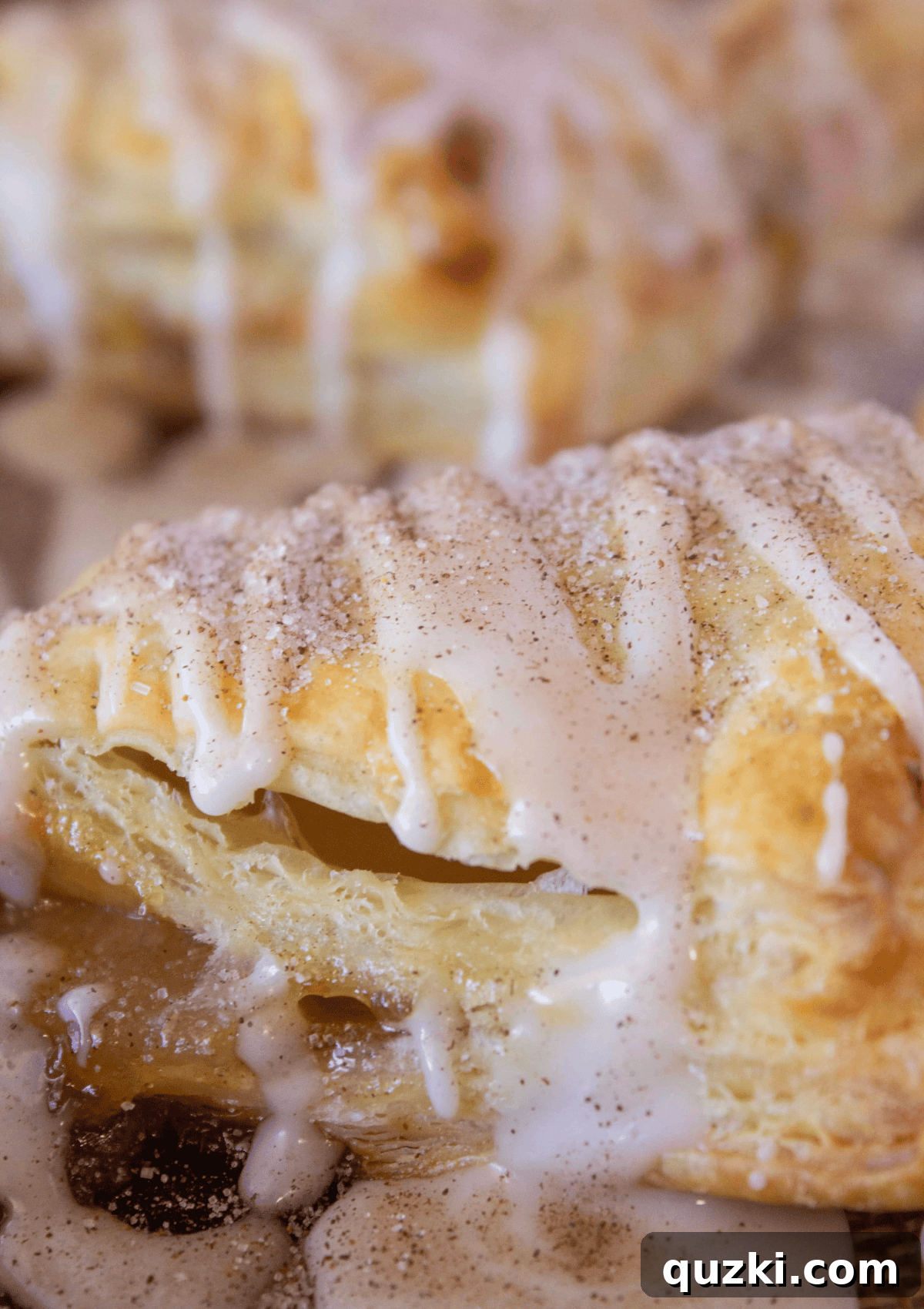 Sweet & Simple Caramel Apple Turnovers 9 Drizzling the sweet apple cider glaze over the freshly baked, golden caramel apple turnovers, ready for a final sprinkle of cinnamon sugar.