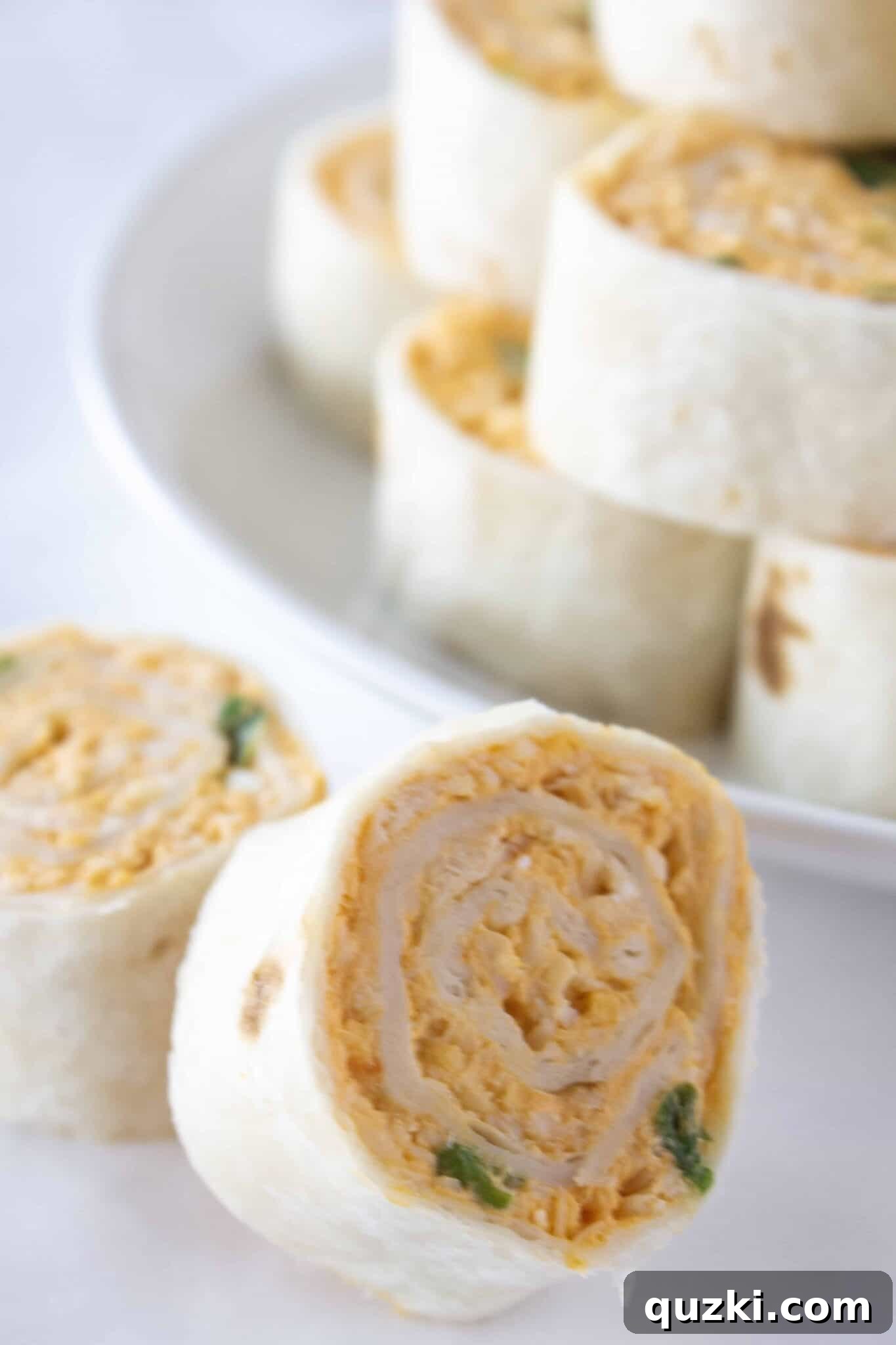The Ultimate Buffalo Chicken Wrap Recipe 8 A close-up view of the inside of one of the Buffalo Chicken Roll Ups, showing the vibrant filling.