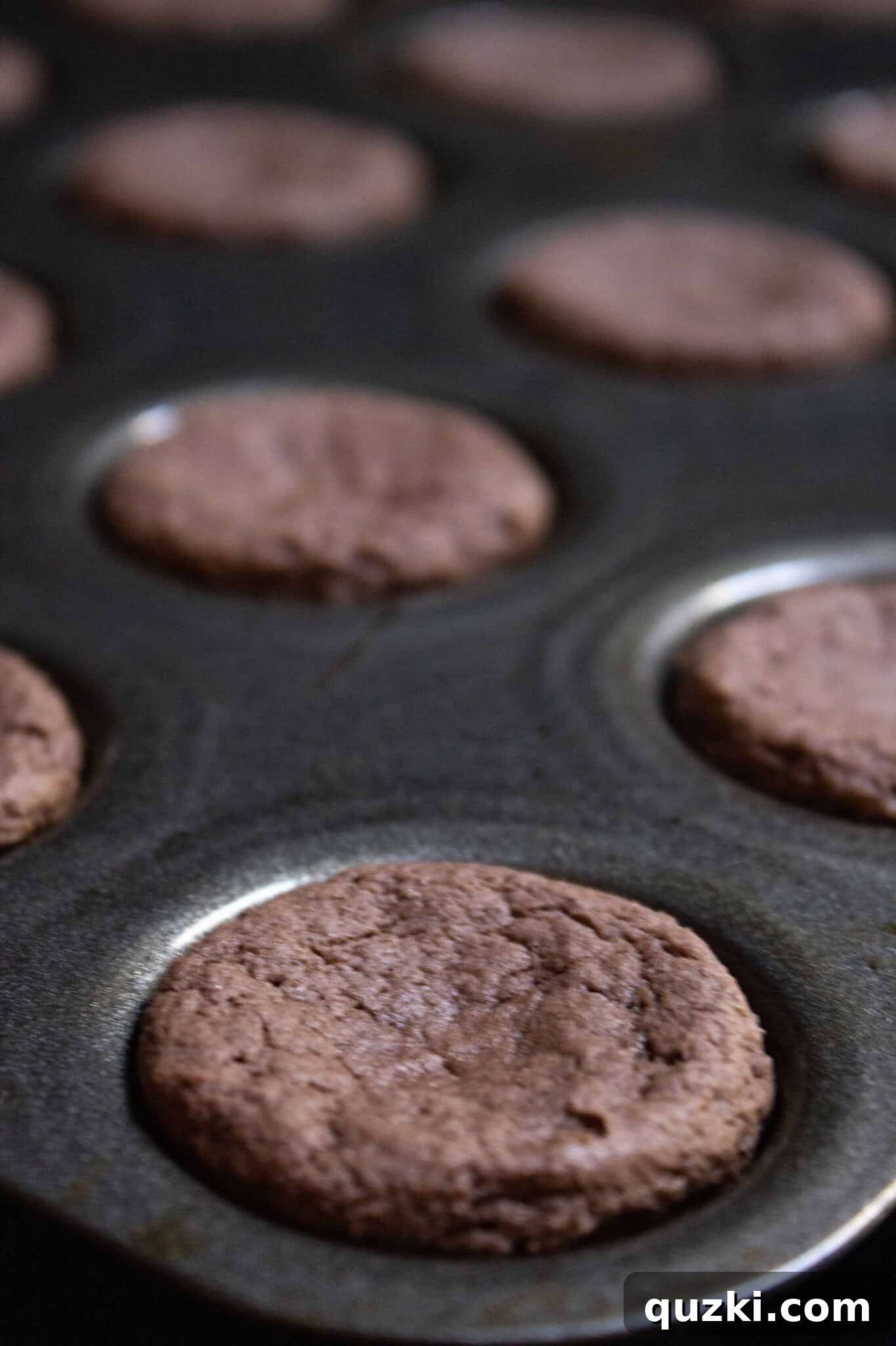 Garden Dirt Cookie Bites 8 The mini muffin pan with freshly baked cookie cups, showcasing their golden-brown edges, ready for the next step.
