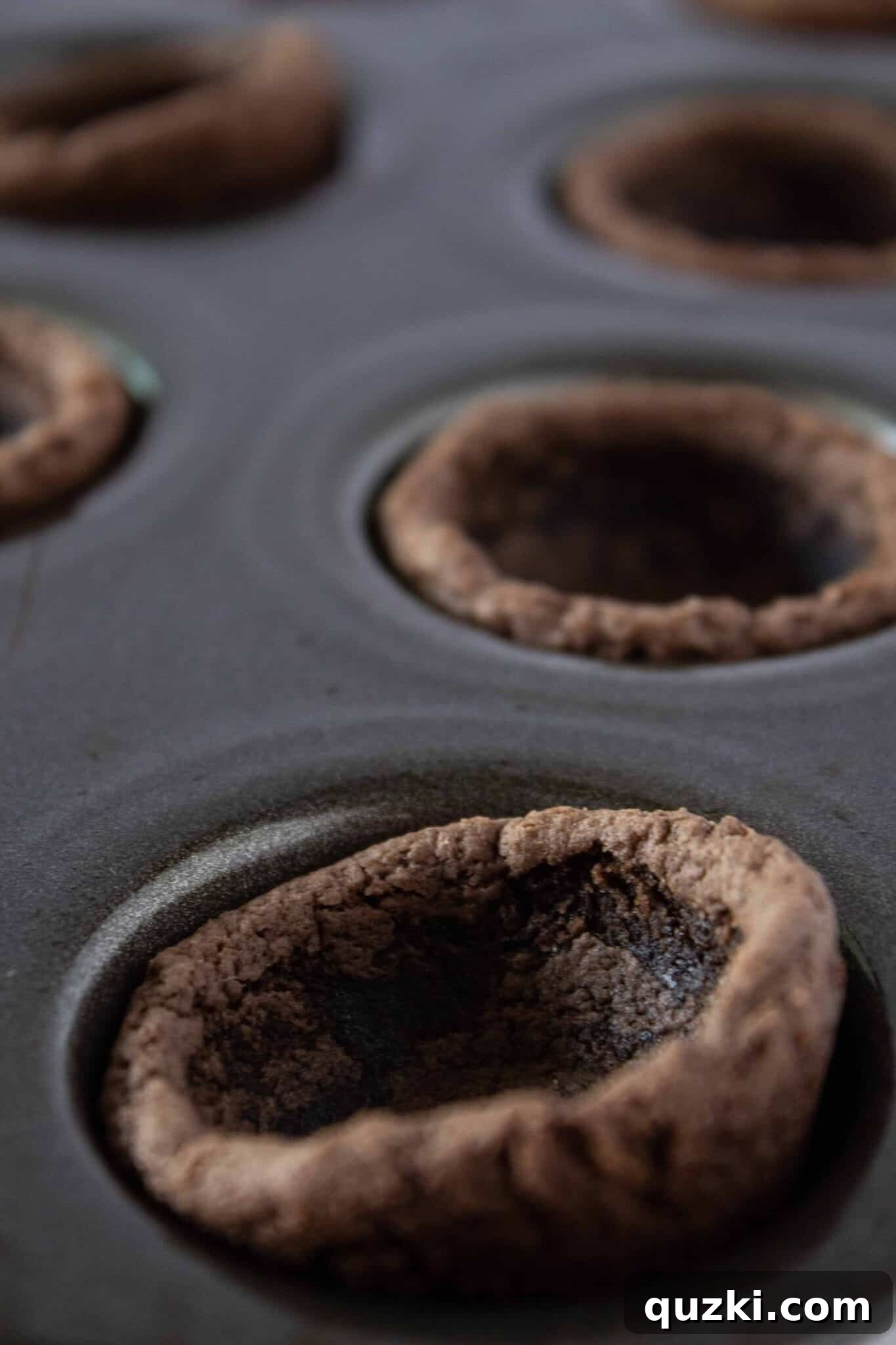 Garden Dirt Cookie Bites 9 Utilizing a tart shaper to carefully make a central indentation in each warm cookie cup, creating the perfect pocket for the filling.