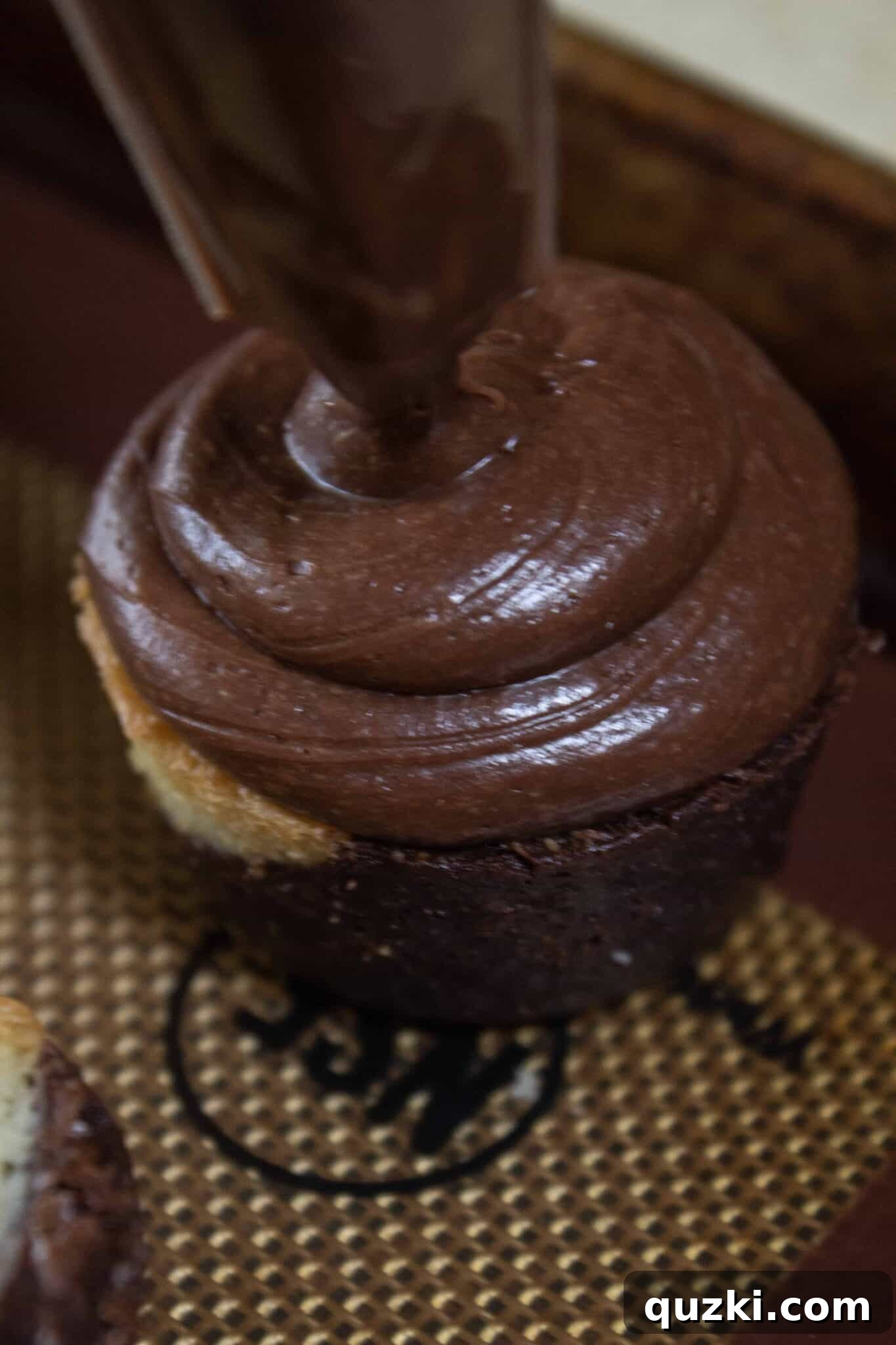 Ghoulish Goodness: Brownie Bat Bites for a Haunting Halloween 4 Piping chocolate frosting onto a brownie bite, demonstrating the first step of the Spooky Brownie Bat Bites recipe creation.