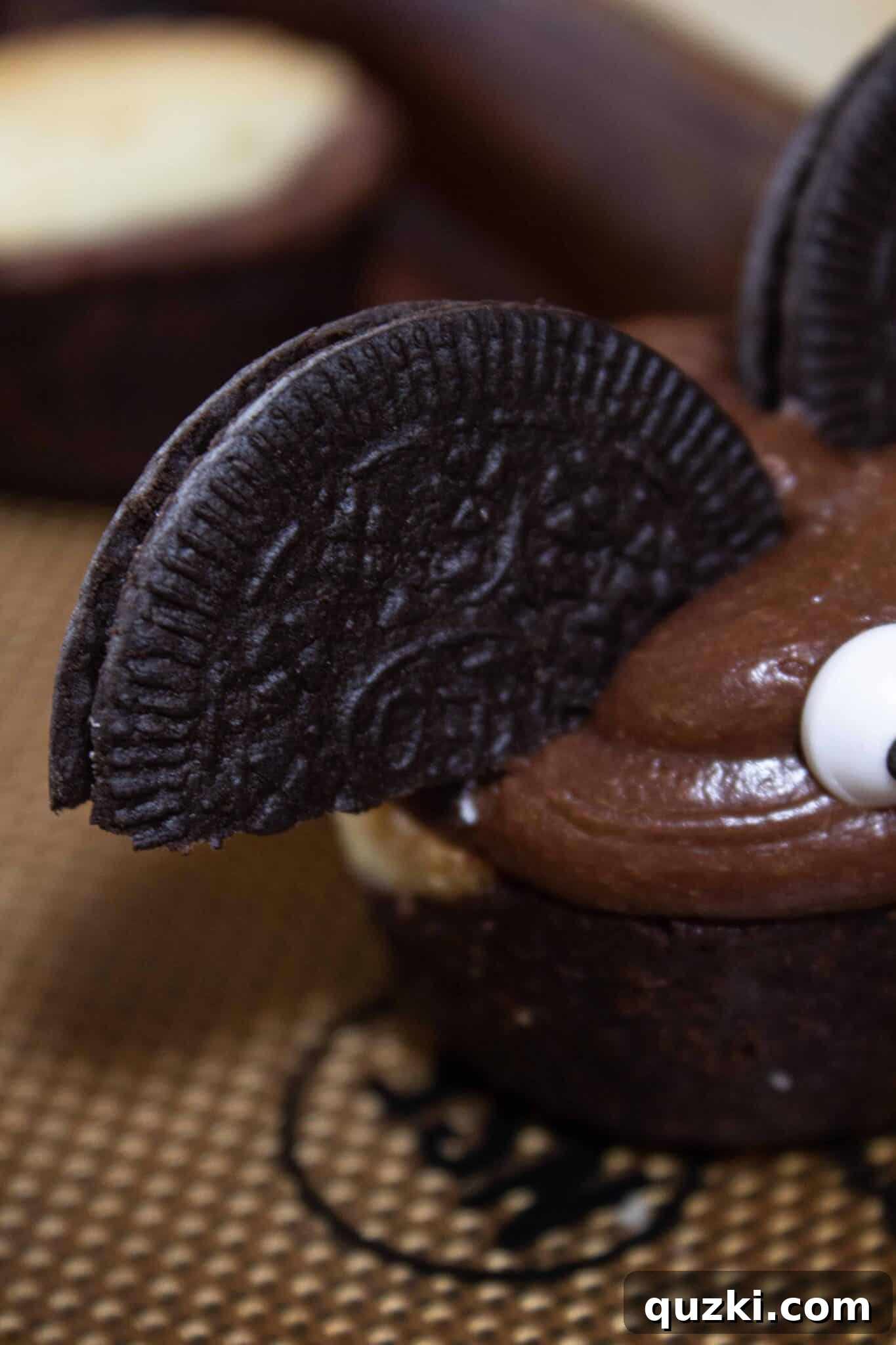 Ghoulish Goodness: Brownie Bat Bites for a Haunting Halloween 6 Inserting two cookie halves into the frosting on a brownie bite to form the distinctive wings of the bat.