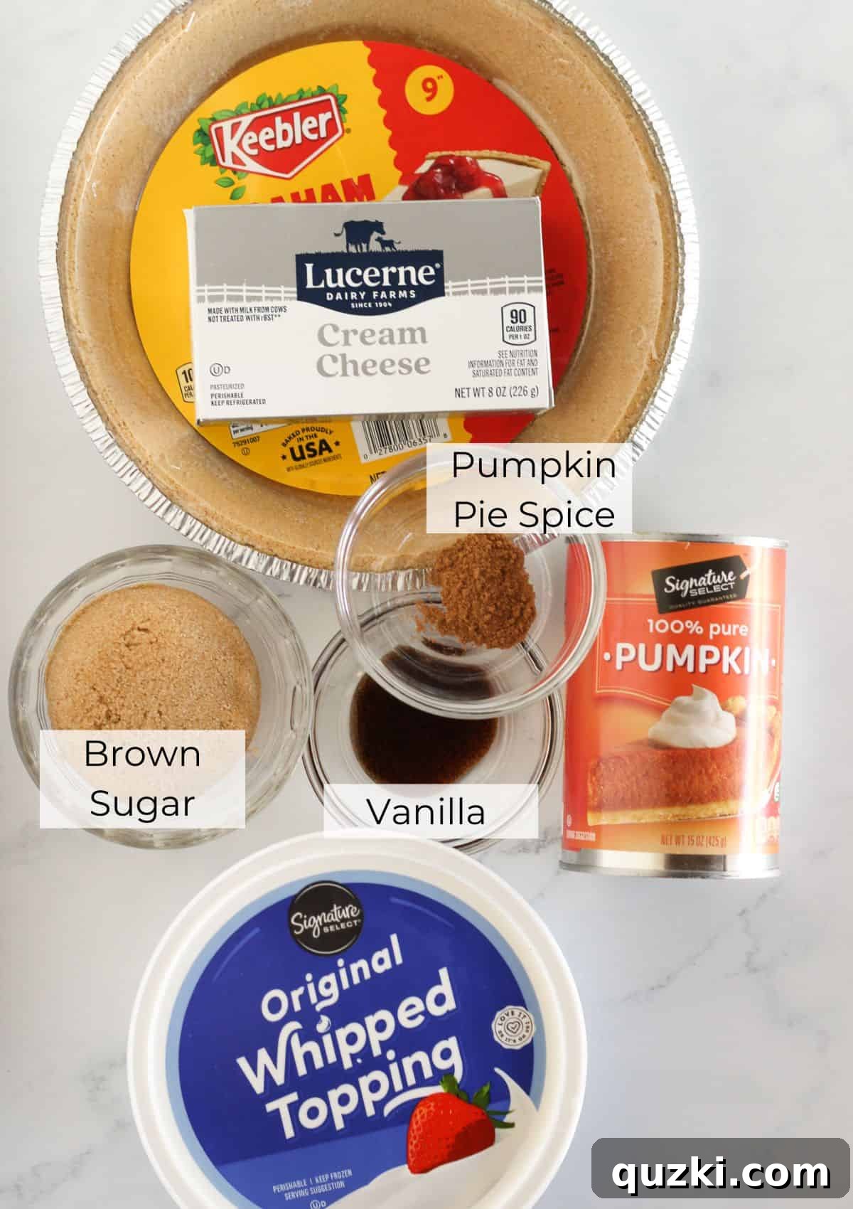 All the necessary ingredients laid out for making a no-bake pumpkin mousse pie: a pre-made graham cracker crust, cream cheese, pumpkin puree, whipped topping, brown sugar, vanilla extract, and pumpkin pie spice.