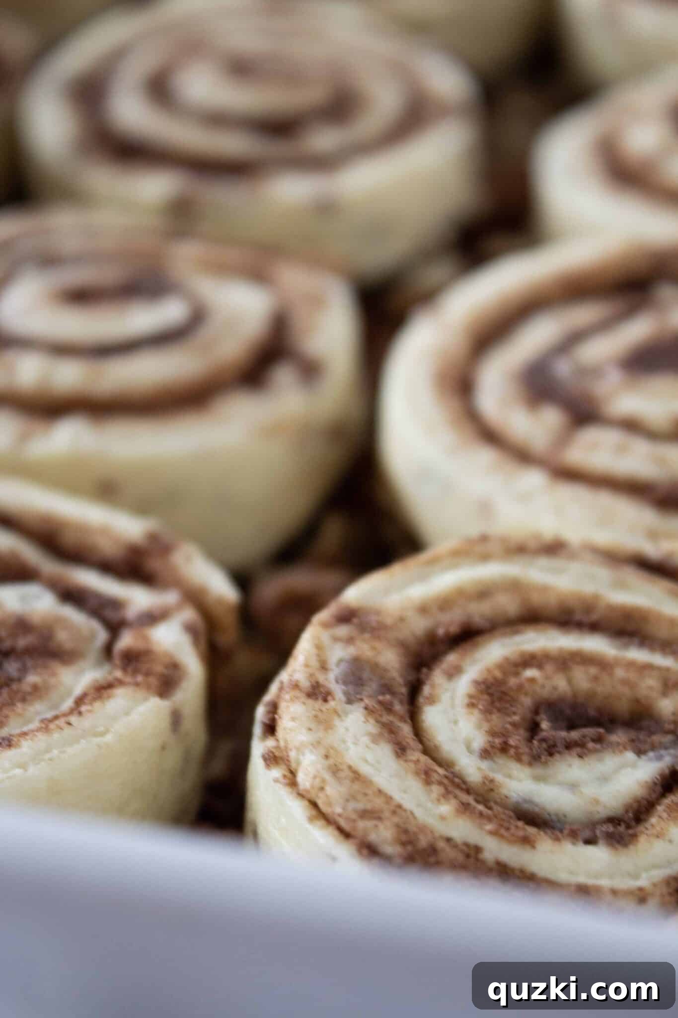 Refrigerated cinnamon rolls placed on top of the caramel pecan mixture in a baking pan