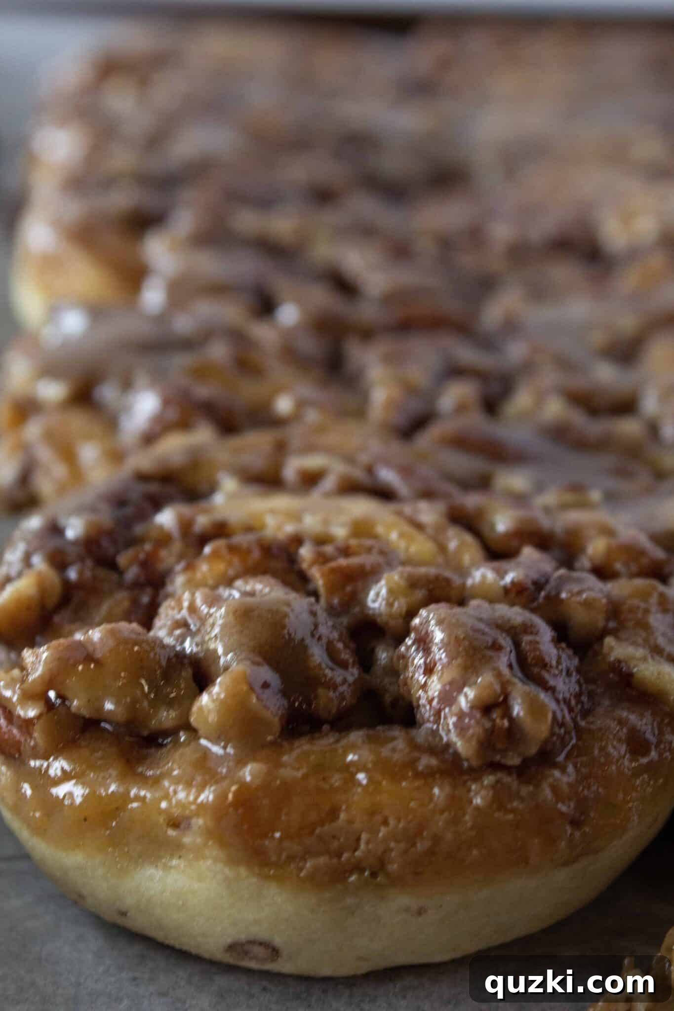 A close-up of a single Easy Caramel Pecan Sticky Bun, showing the layers and the sticky topping