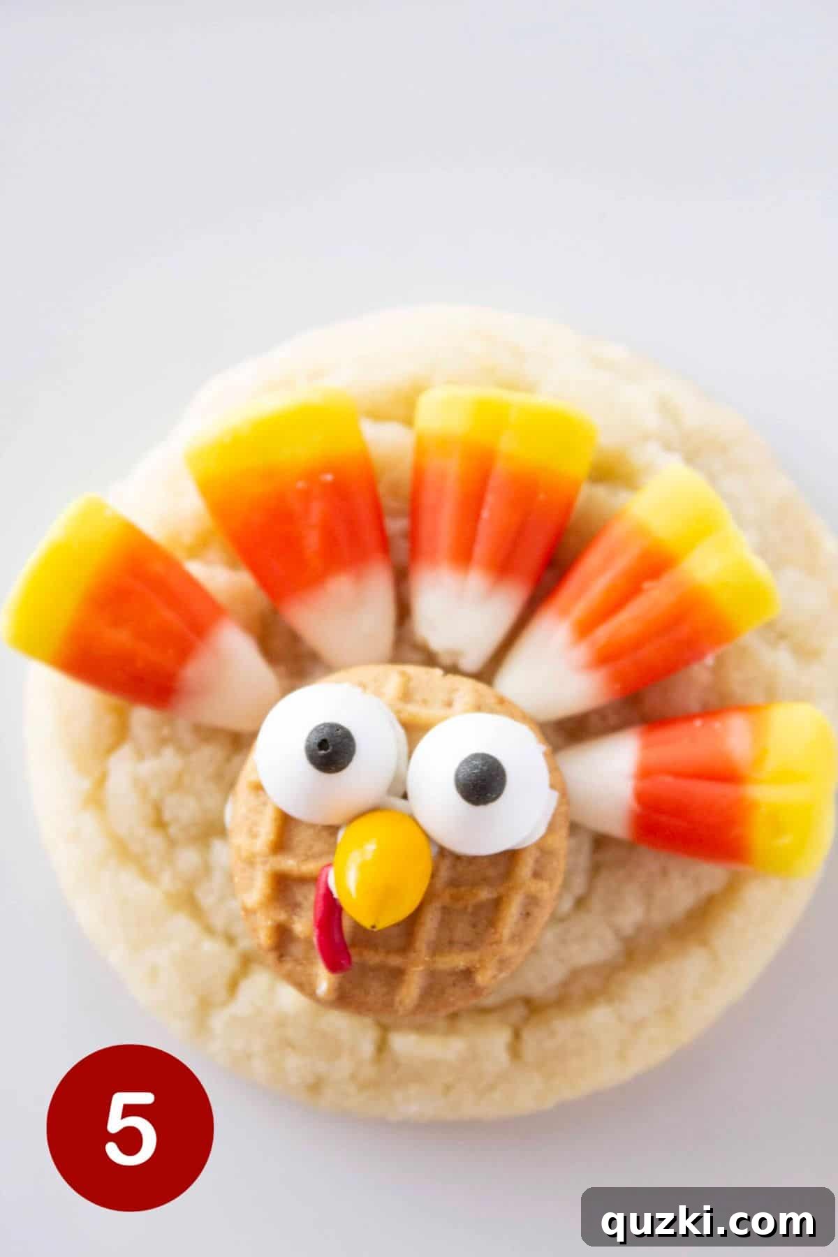 Effortless Thanksgiving Turkey Cookies 6 Step 5 shows a fully decorated turkey cookie with five candy corn candies arranged in a fan shape as its colorful tail feathers, set against the sugar cookie base.