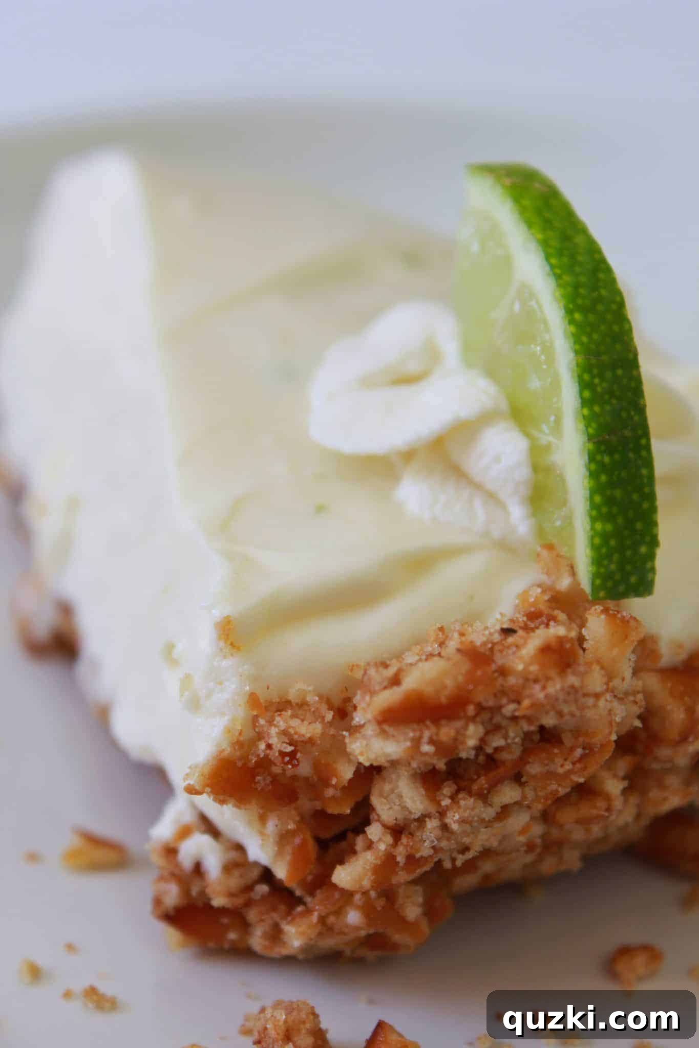 Refreshing No Bake Key Lime Pie with a pretzel crust, garnished with lime slices, presented as an unexpected Thanksgiving dessert.