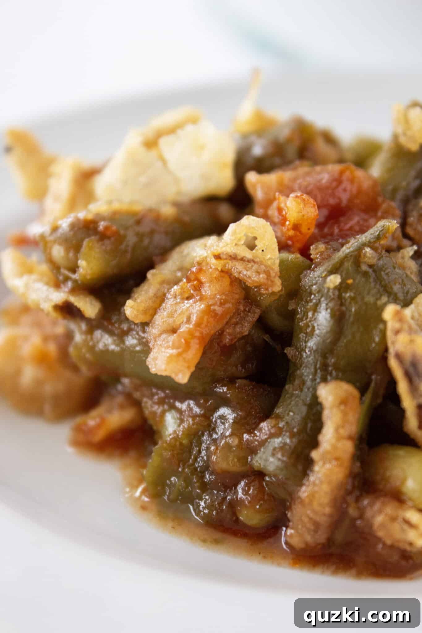 A delicious serving of BBQ Green Bean Casserole on a white plate, ready to be enjoyed as a perfect side dish.