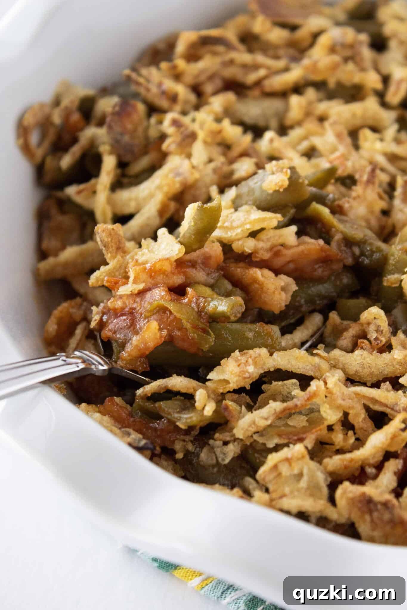 Serving a generous scoop of the delectable BBQ Green Bean Casserole onto a plate.