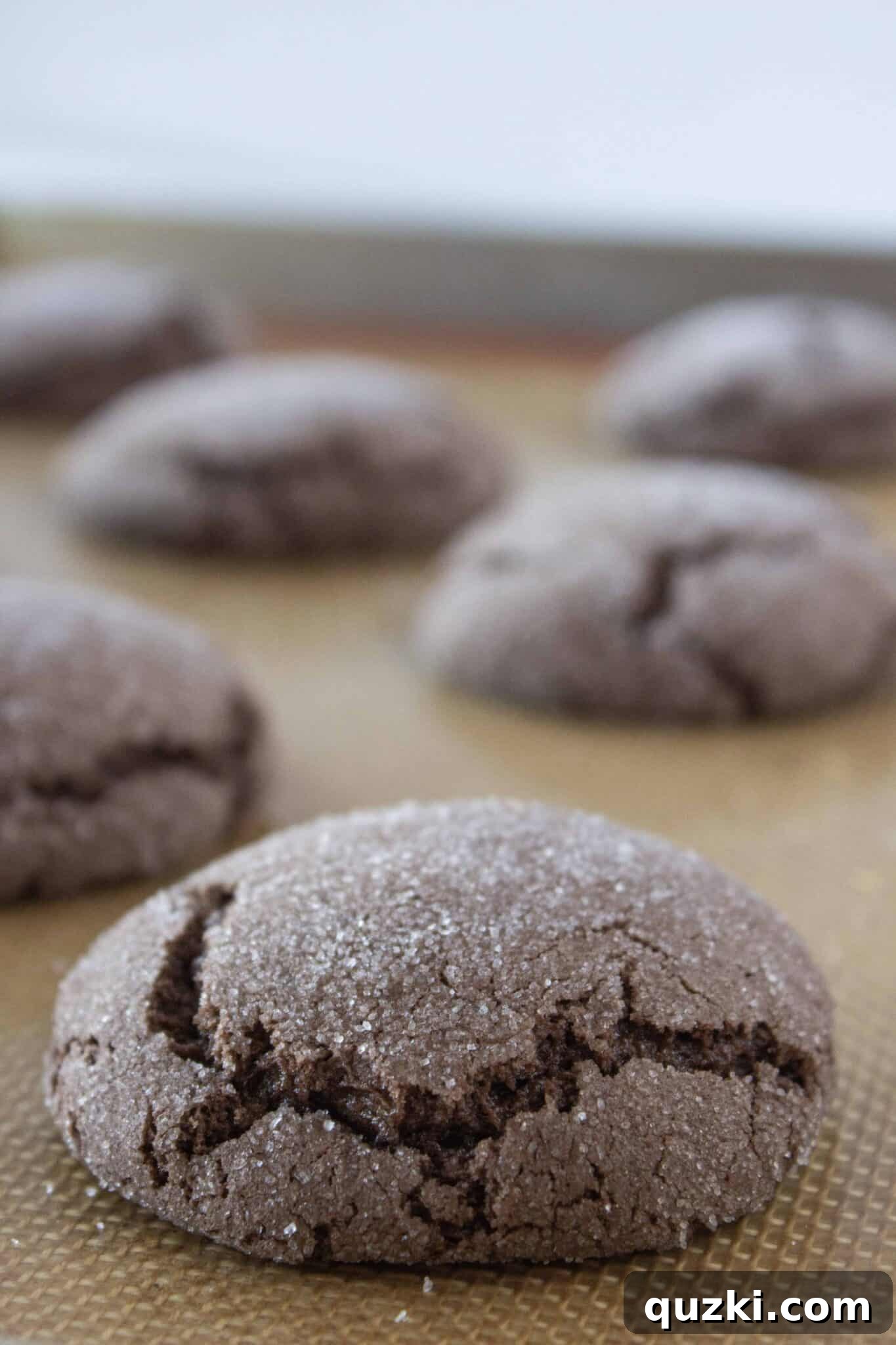 Prepping the Hershey's Kisses and freshly baked chocolate cookies on a baking sheet.