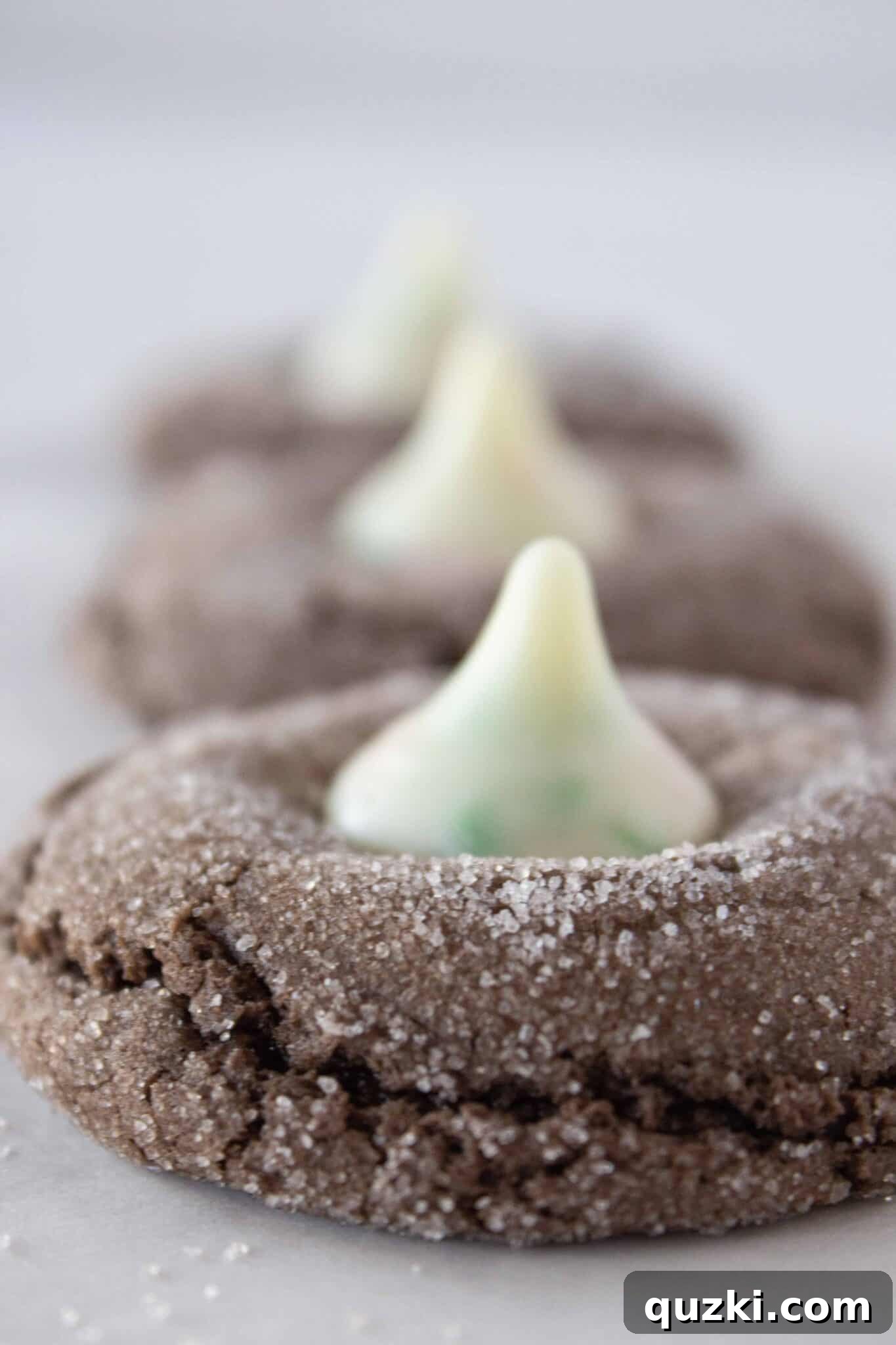 Pressing the kisses into the top of each chocolate cookie and letting them cool.