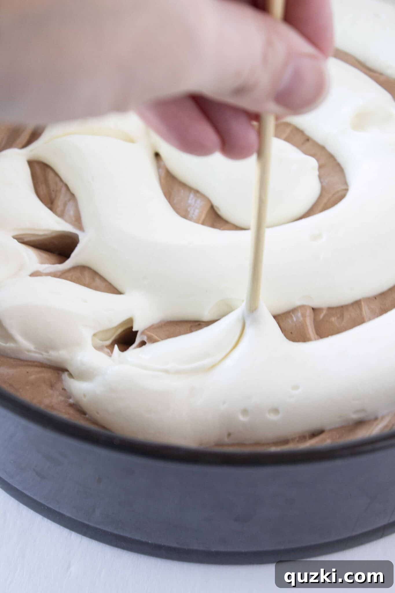 Gracefully swirling the chocolate and vanilla cheesecake batters together for a stunning marbled effect.