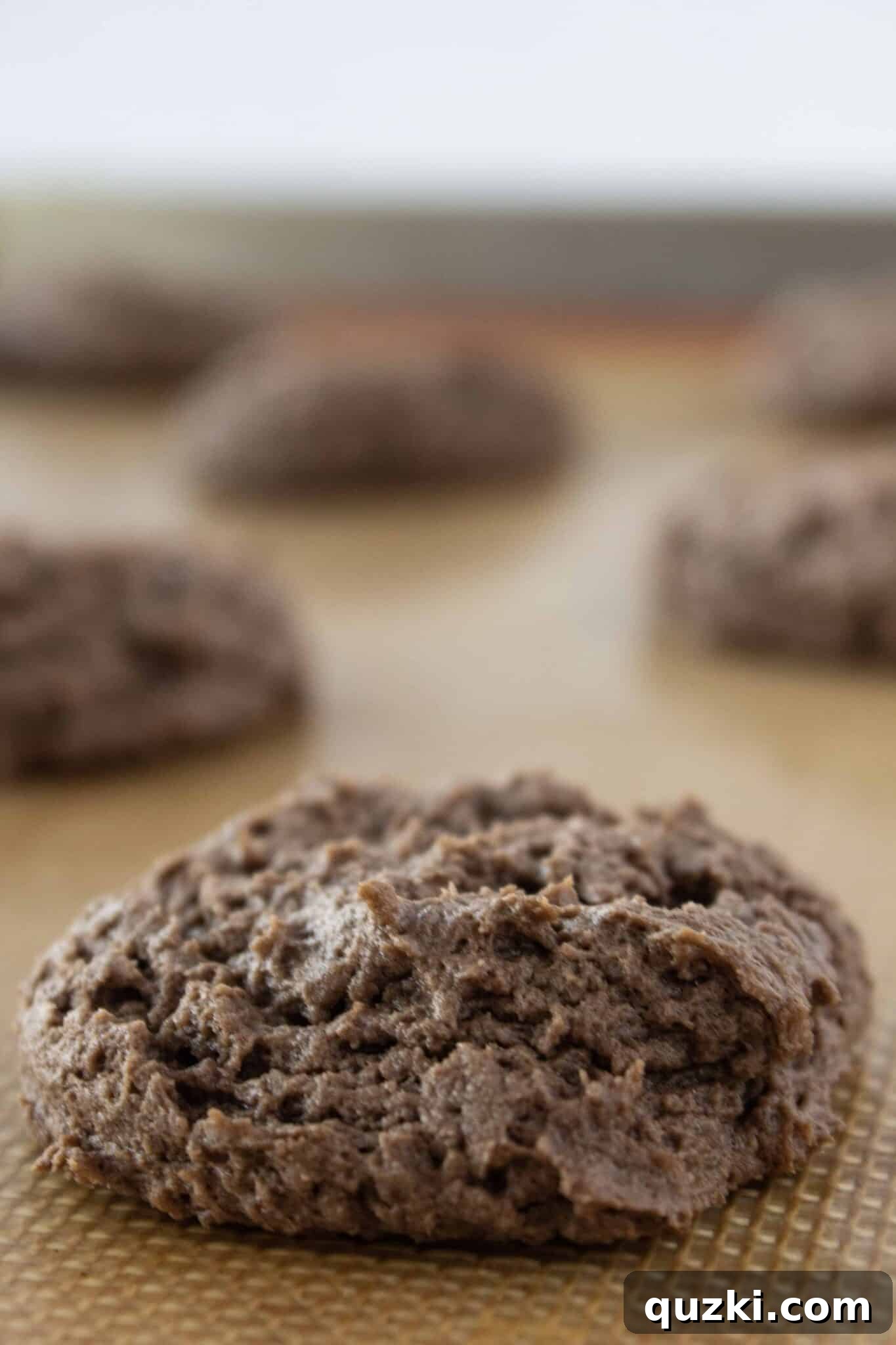 Effortless Cake Mix Cream Cheese Chocolate Cookies 7 Freshly baked Chocolate Cream Cheese Cake Mix Cookies cooling on a baking sheet, appearing slightly soft in the middle