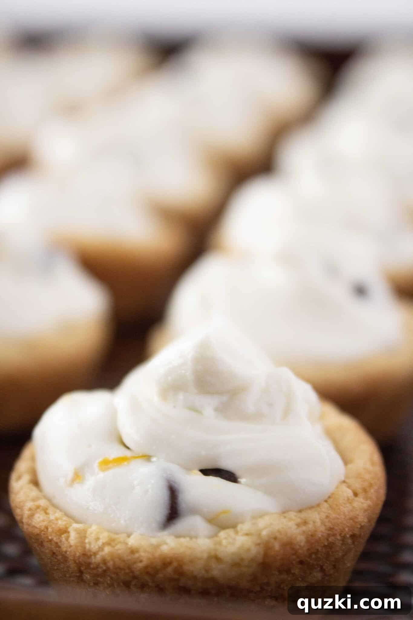 Filling the baked cookie cups with the creamy cannoli mixture using a piping bag for precision.