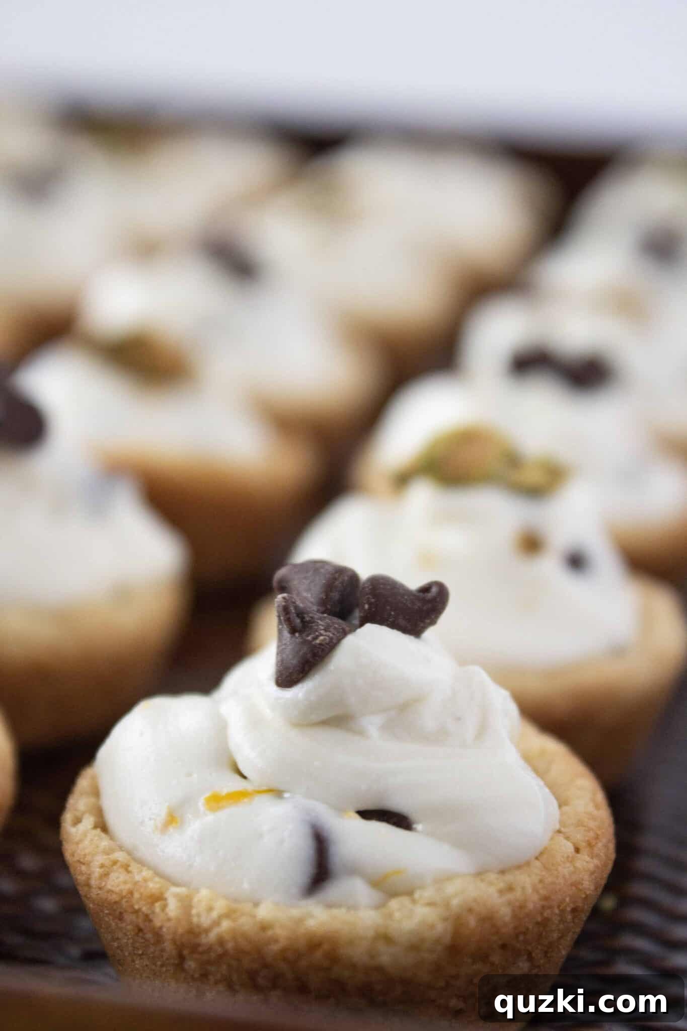 Finished Cannoli Cookie Cups neatly arranged on a baking tray, garnished and ready for serving.