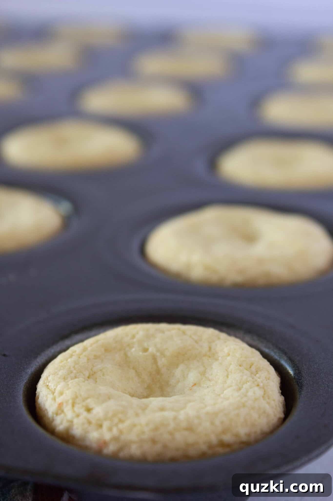Baked cake mix cookies in a mini muffin pan, freshly removed from the oven and ready for the next step.
