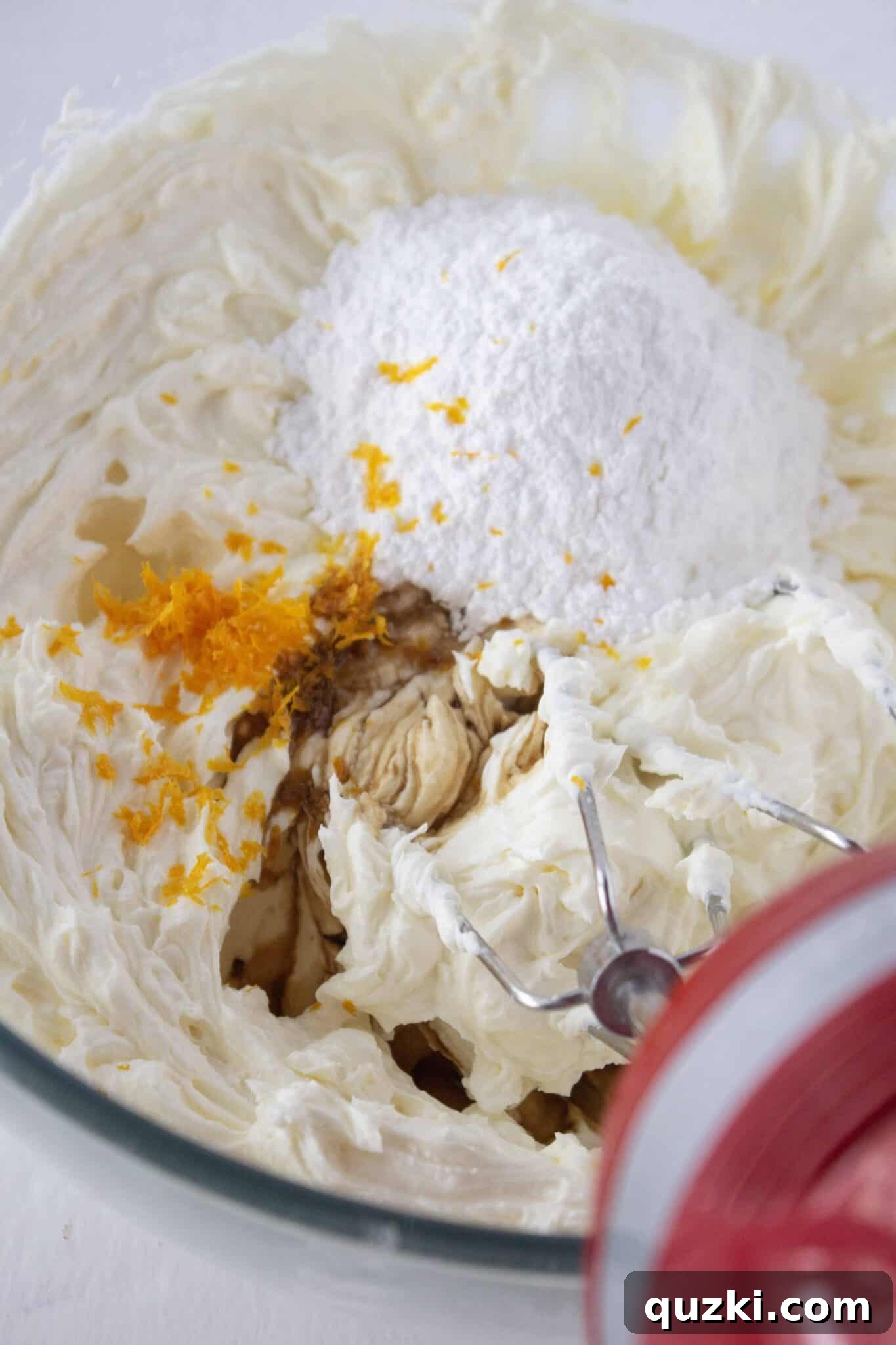 The creamy cannoli filling ingredients in a bowl, featuring a generous amount of fresh orange zest.