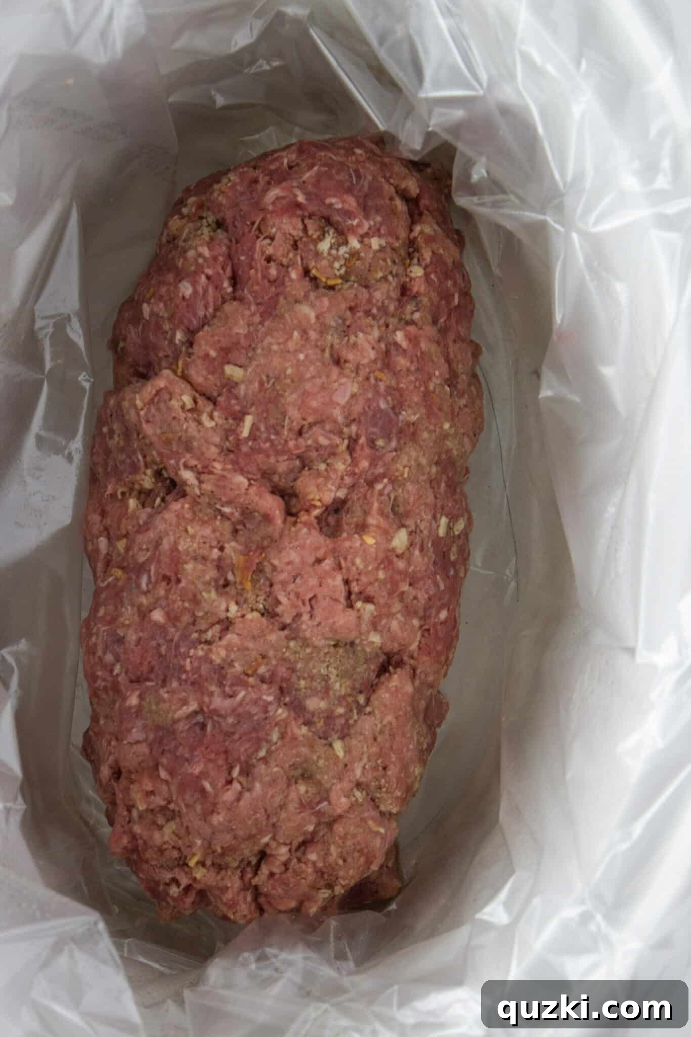 Shaping the meatloaf mixture into a log within the crock pot.