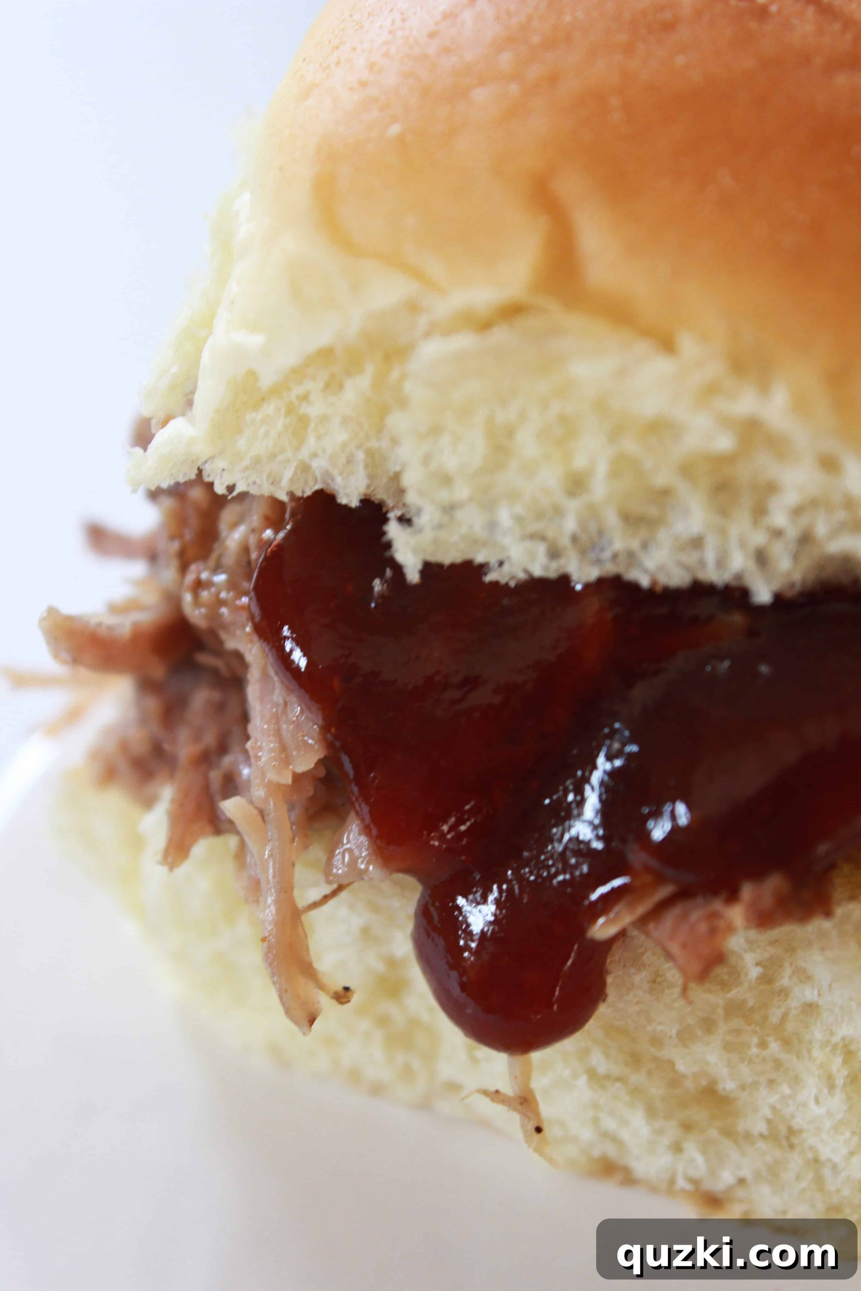 Delicious Crock Pot Pulled Pork Sliders on a wooden board with a side of coleslaw, perfect for easy New Year recipes
