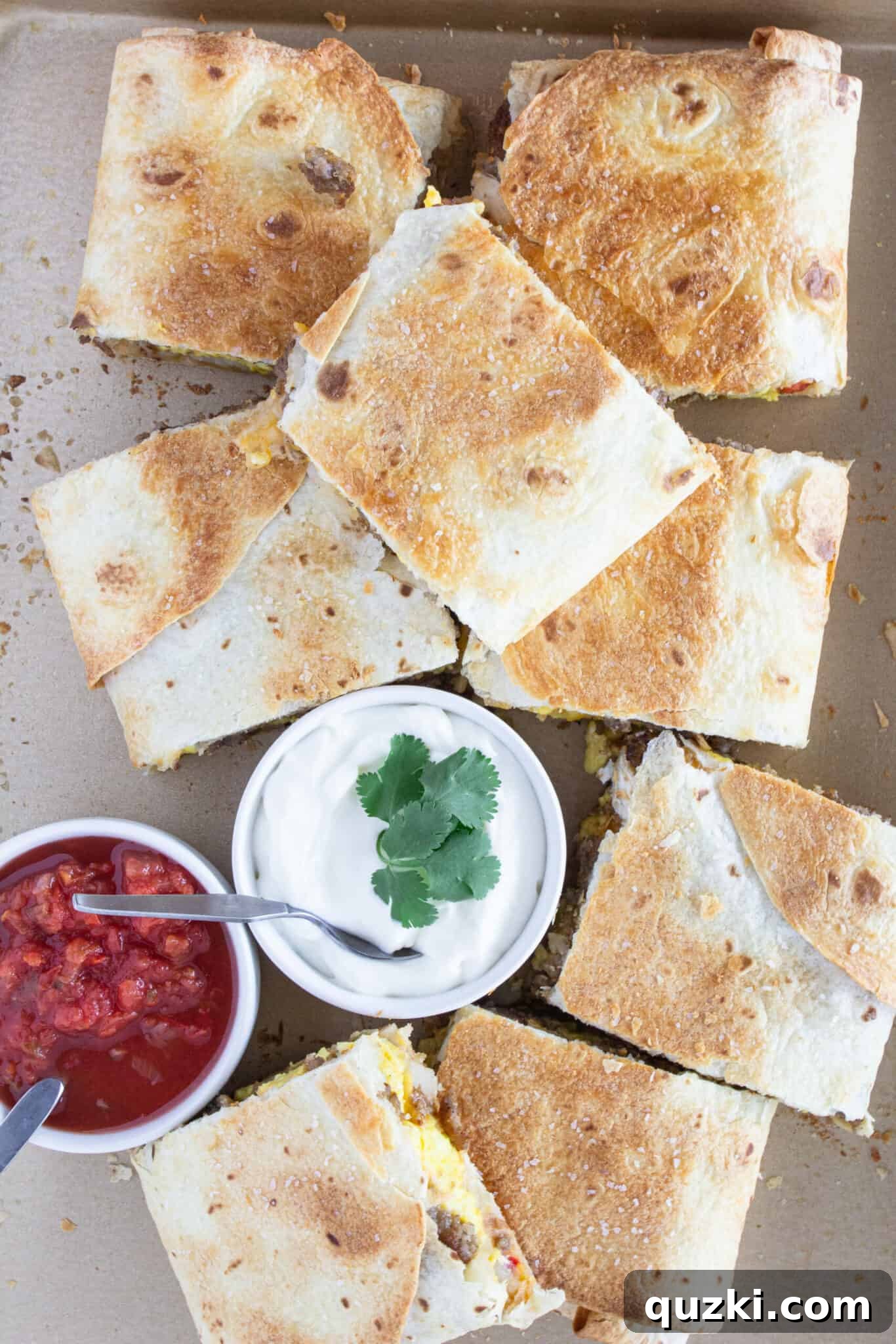 Easy Sheet Pan Breakfast Quesadillas 3 Looking down at a Sheet Pan Breakfast Quesadilla with sour cream and cilantro.