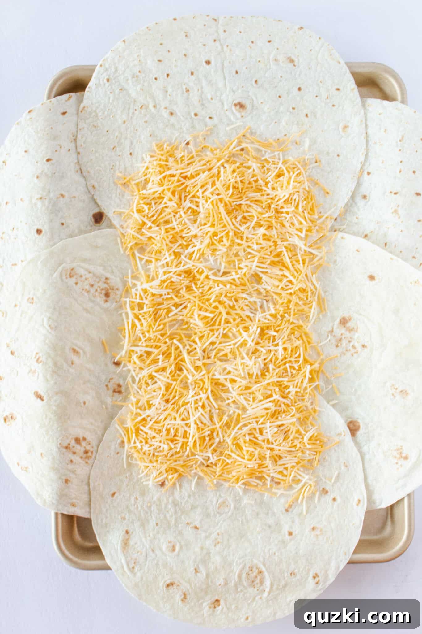 Easy Sheet Pan Breakfast Quesadillas 5 Laying out the tortilla and adding the cheese to the top.