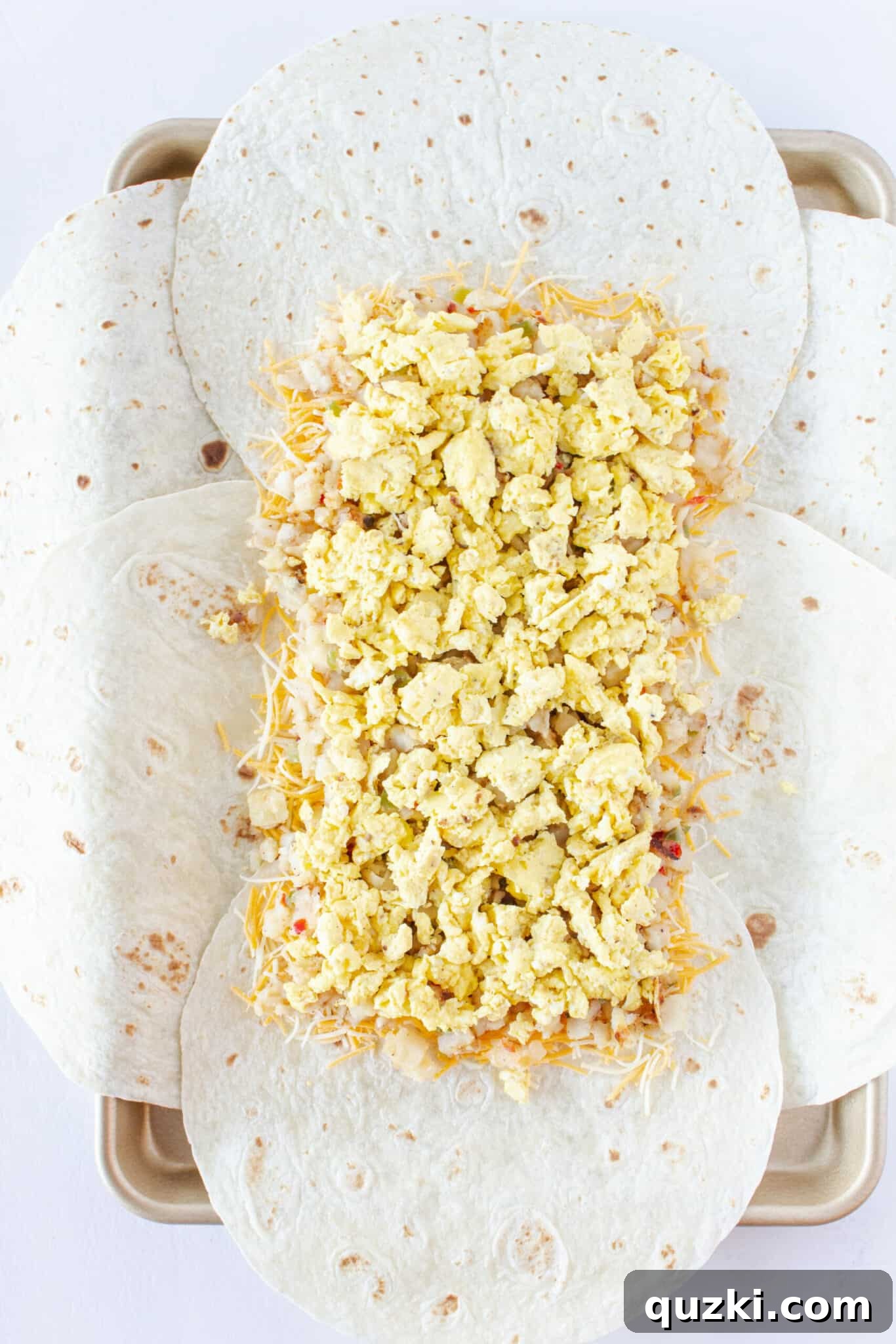 Easy Sheet Pan Breakfast Quesadillas 7 Adding the hashbrowns and scrambled eggs to the top of the cheese layer.