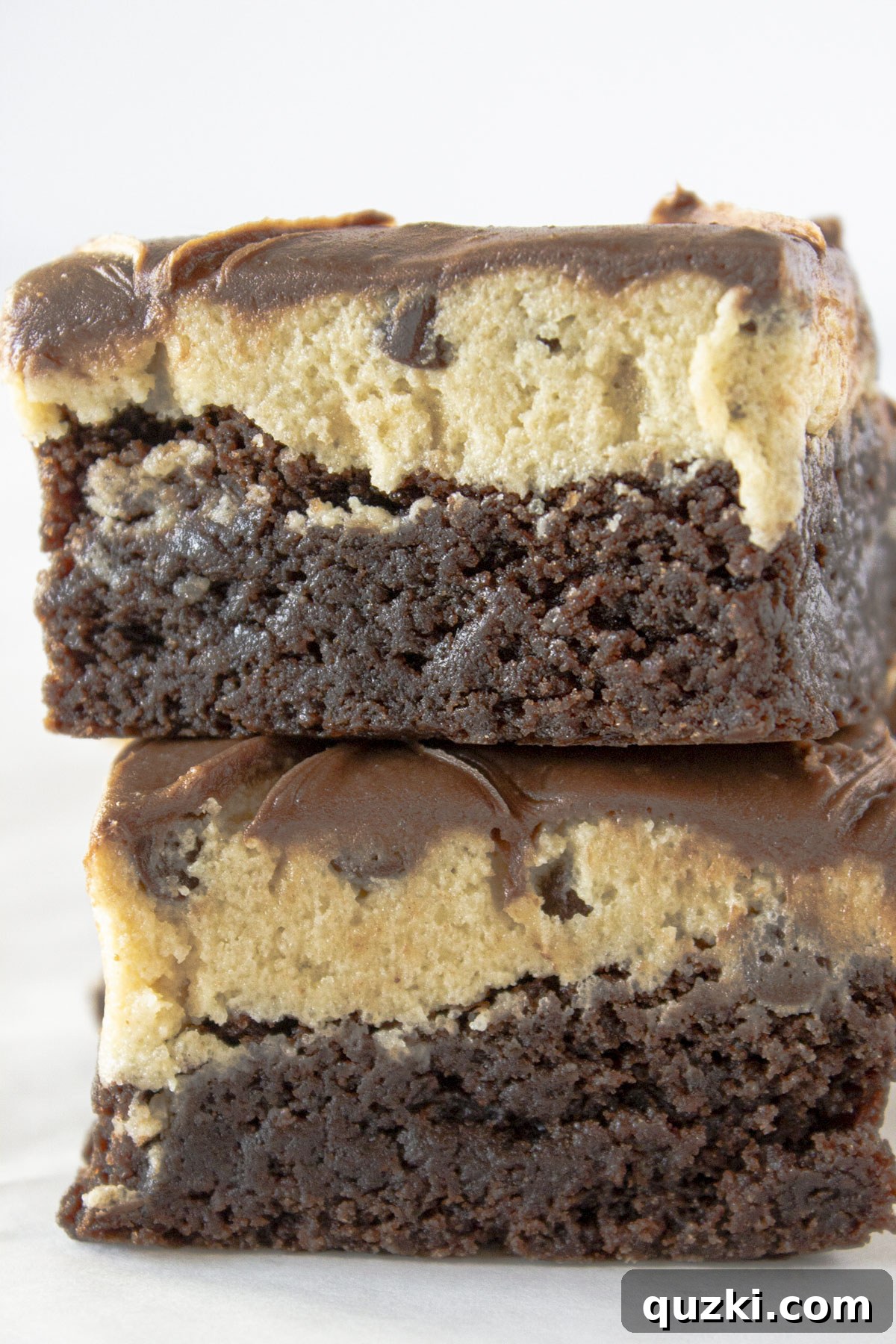 Two Cookie Dough Brownies stacked on top of each other, showcasing their delicious layers.