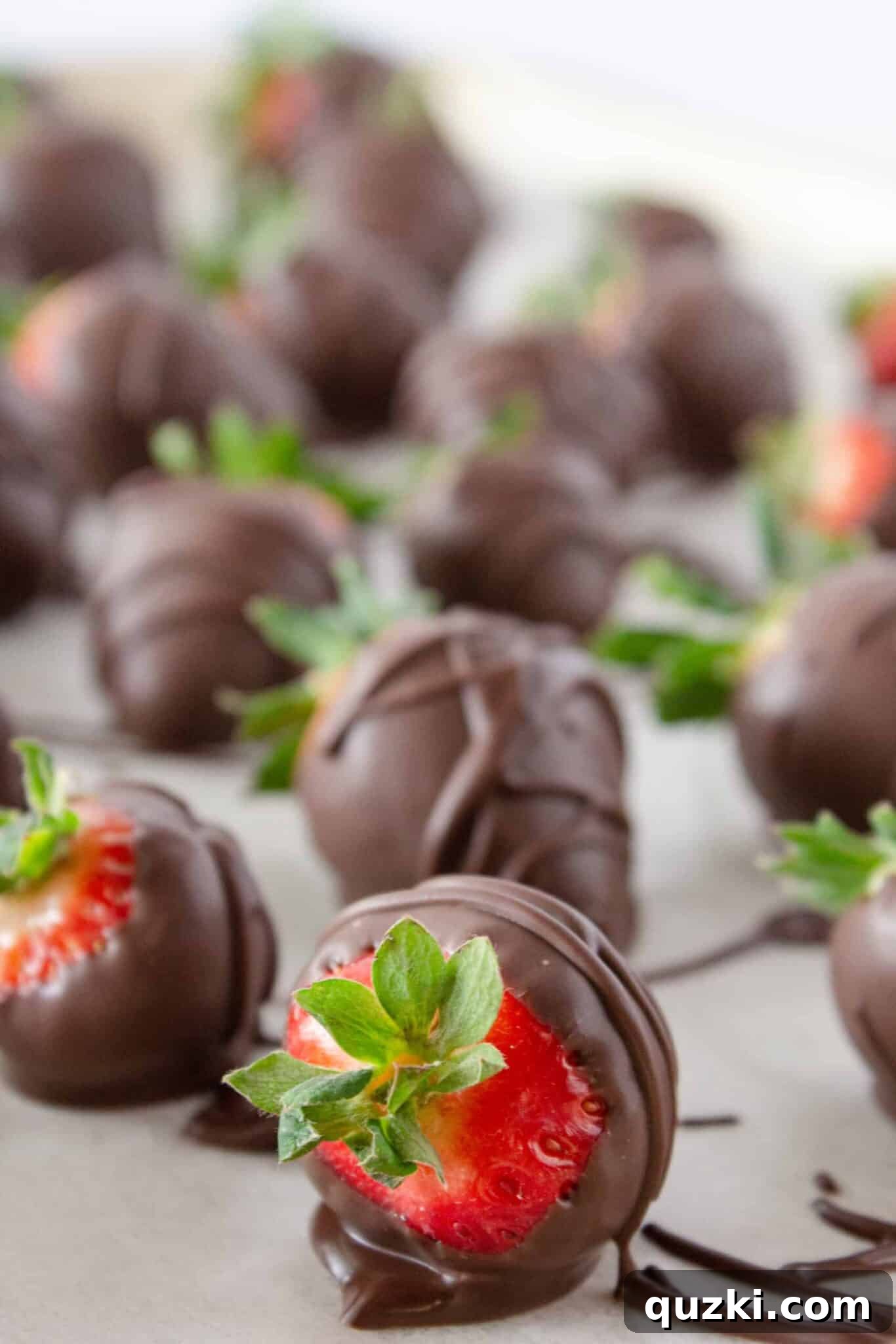 Luscious Chocolate Dipped Strawberry Cookie Cups 11 A hand dipping a fresh strawberry into a bowl of melted chocolate, creating the classic chocolate-covered strawberry treat.