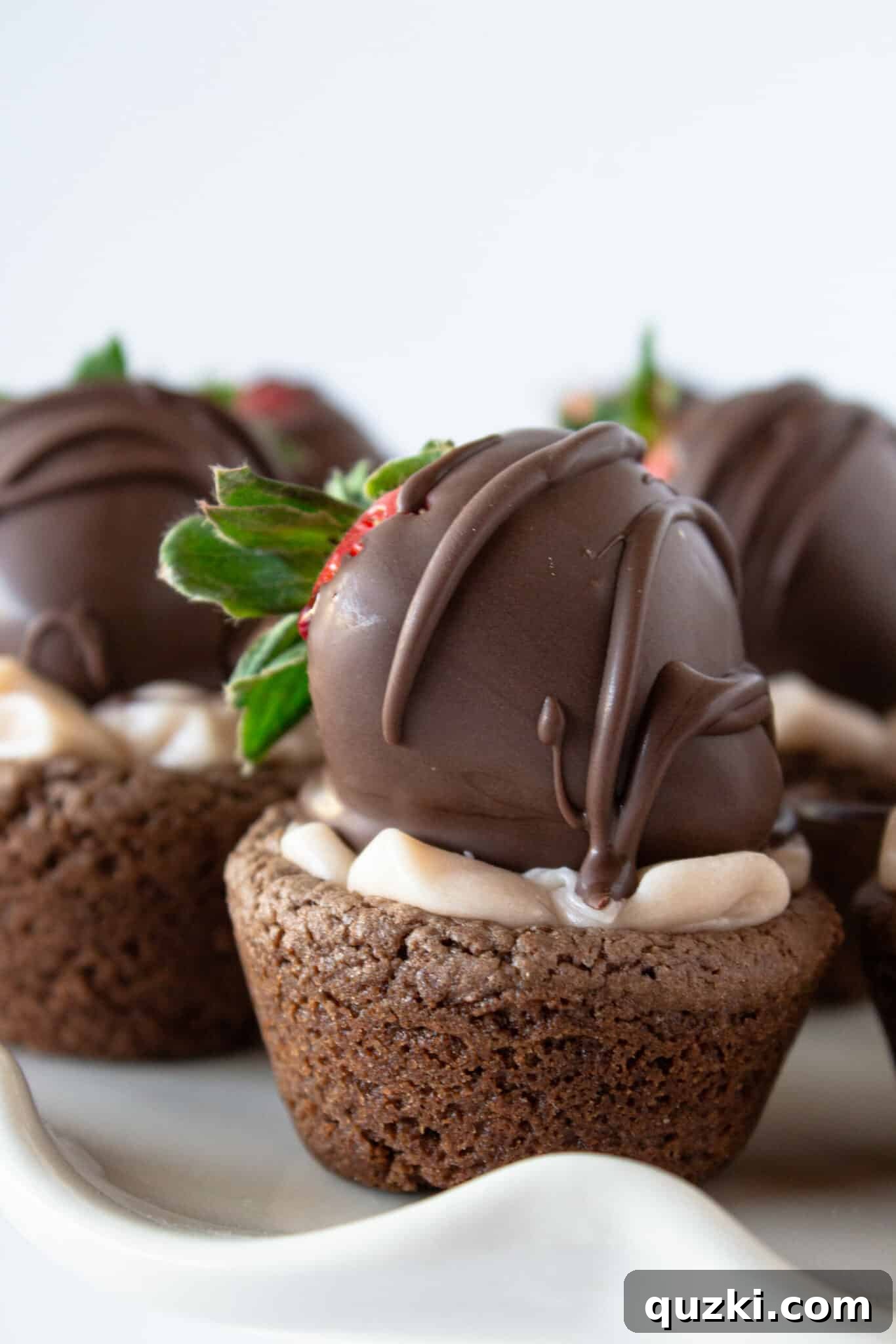 Luscious Chocolate Dipped Strawberry Cookie Cups 15 A stunning arrangement of Chocolate Covered Strawberry Cookie Cups on a tiered white cake plate, ready for serving at a gathering.