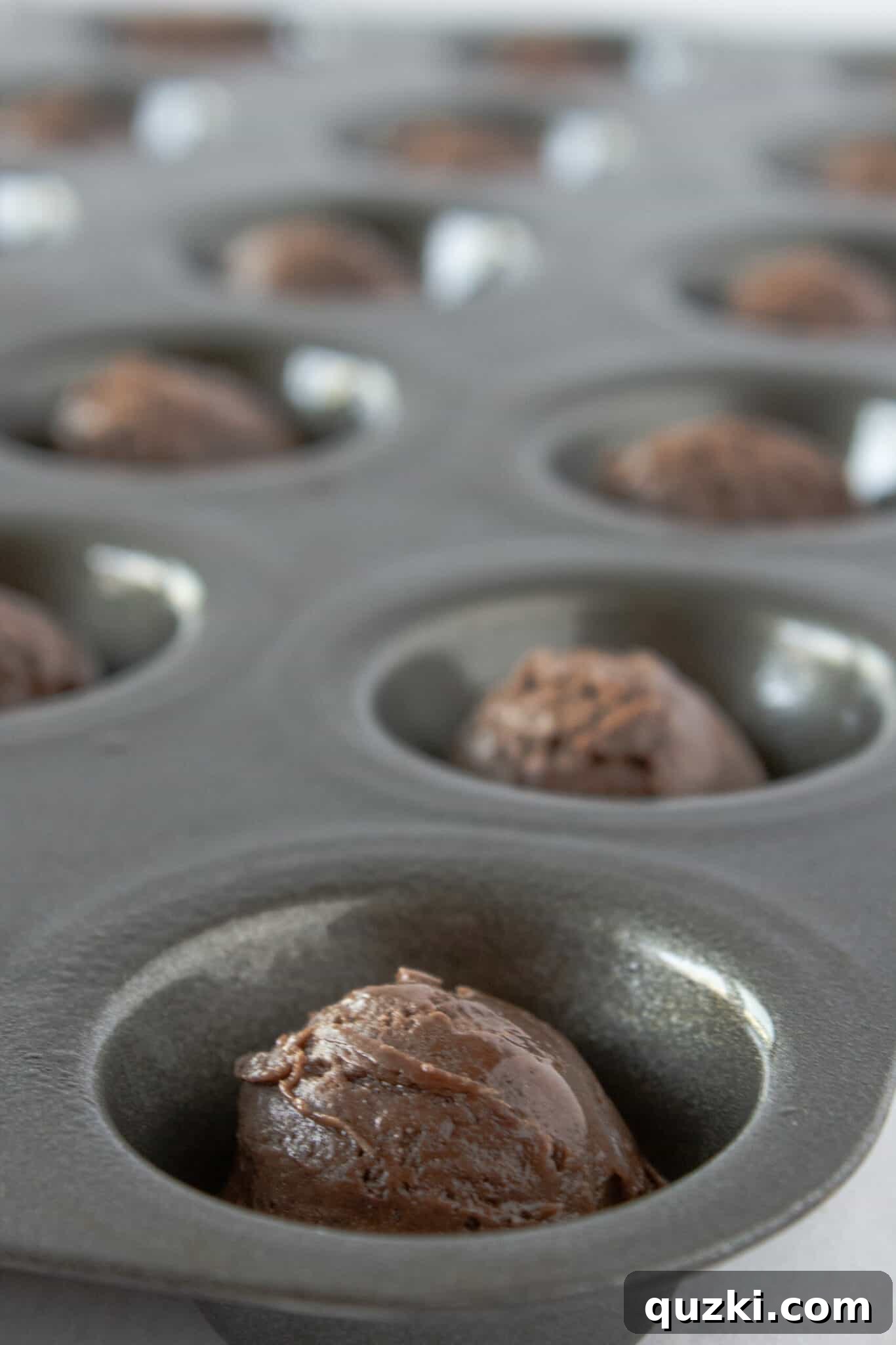 Luscious Chocolate Dipped Strawberry Cookie Cups 5 Hands demonstrating the process of scooping cookie dough into a mini muffin pan.