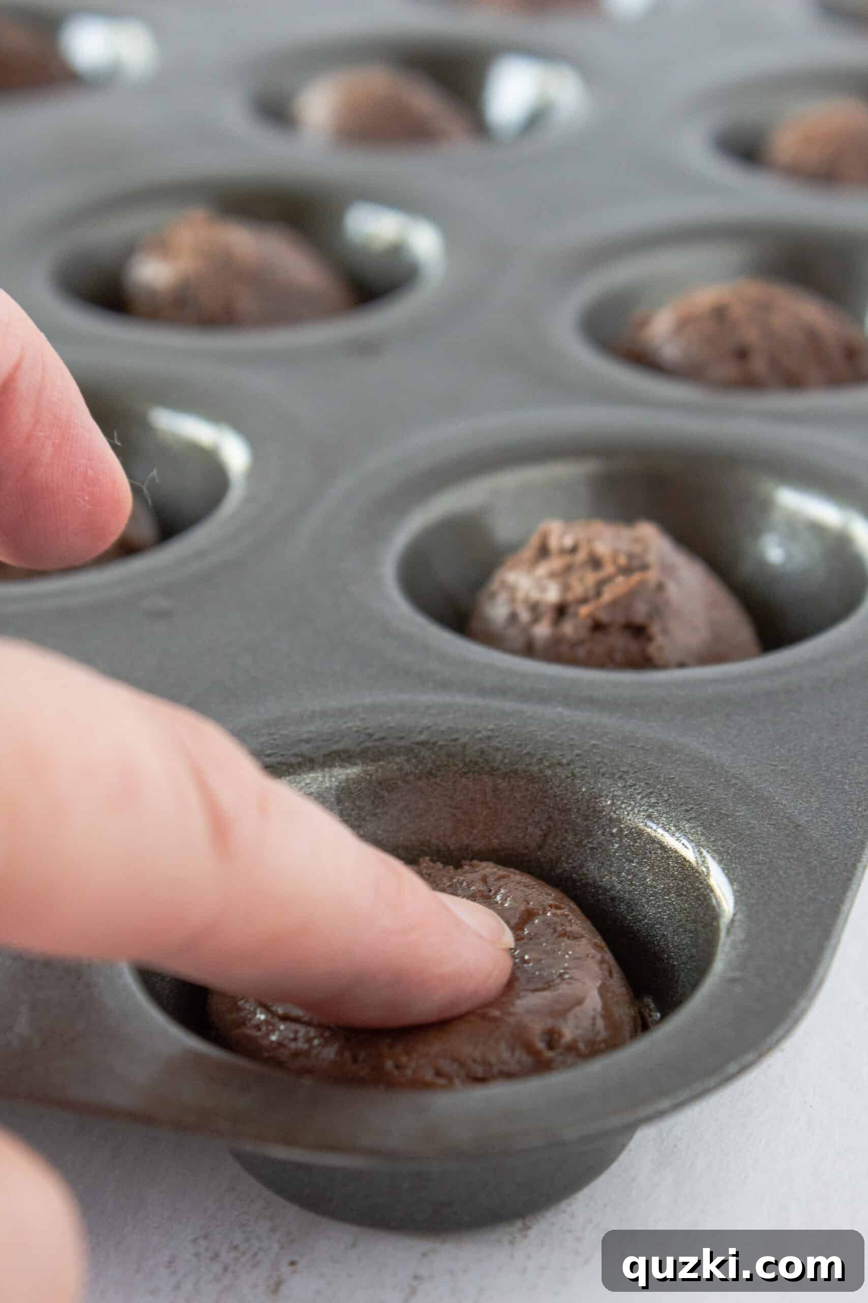 Luscious Chocolate Dipped Strawberry Cookie Cups 6 Close-up of baked chocolate cookie cups in a mini muffin pan, demonstrating the ideal texture before making indentations.