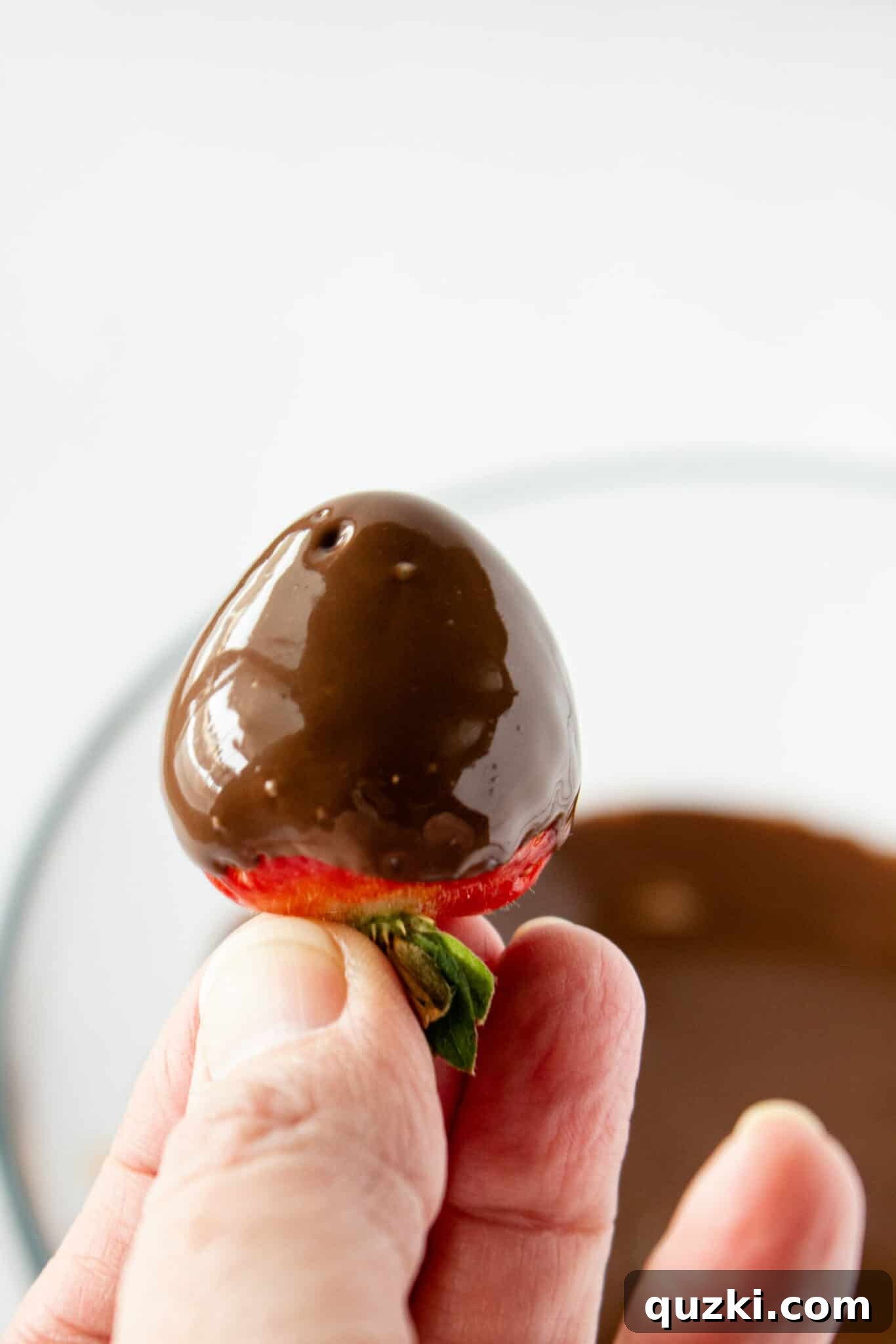 Luscious Chocolate Dipped Strawberry Cookie Cups 10 A collection of freshly dipped chocolate-covered strawberries on parchment paper, showcasing the smooth chocolate coating.