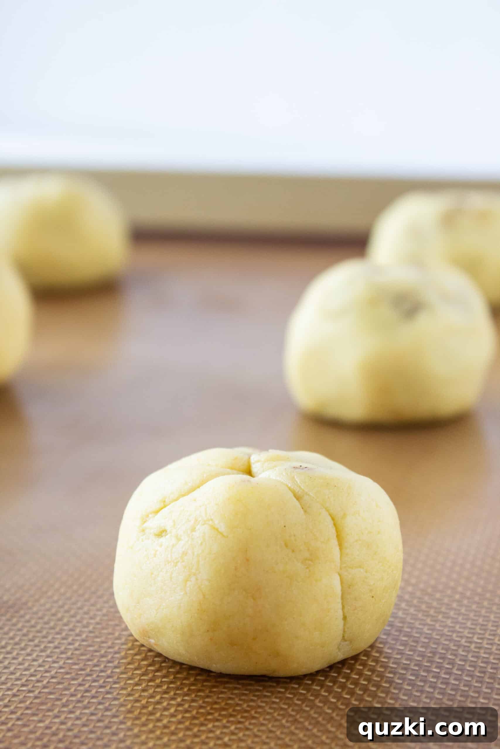 Baked cinnamon roll cookies cooling on a baking sheet