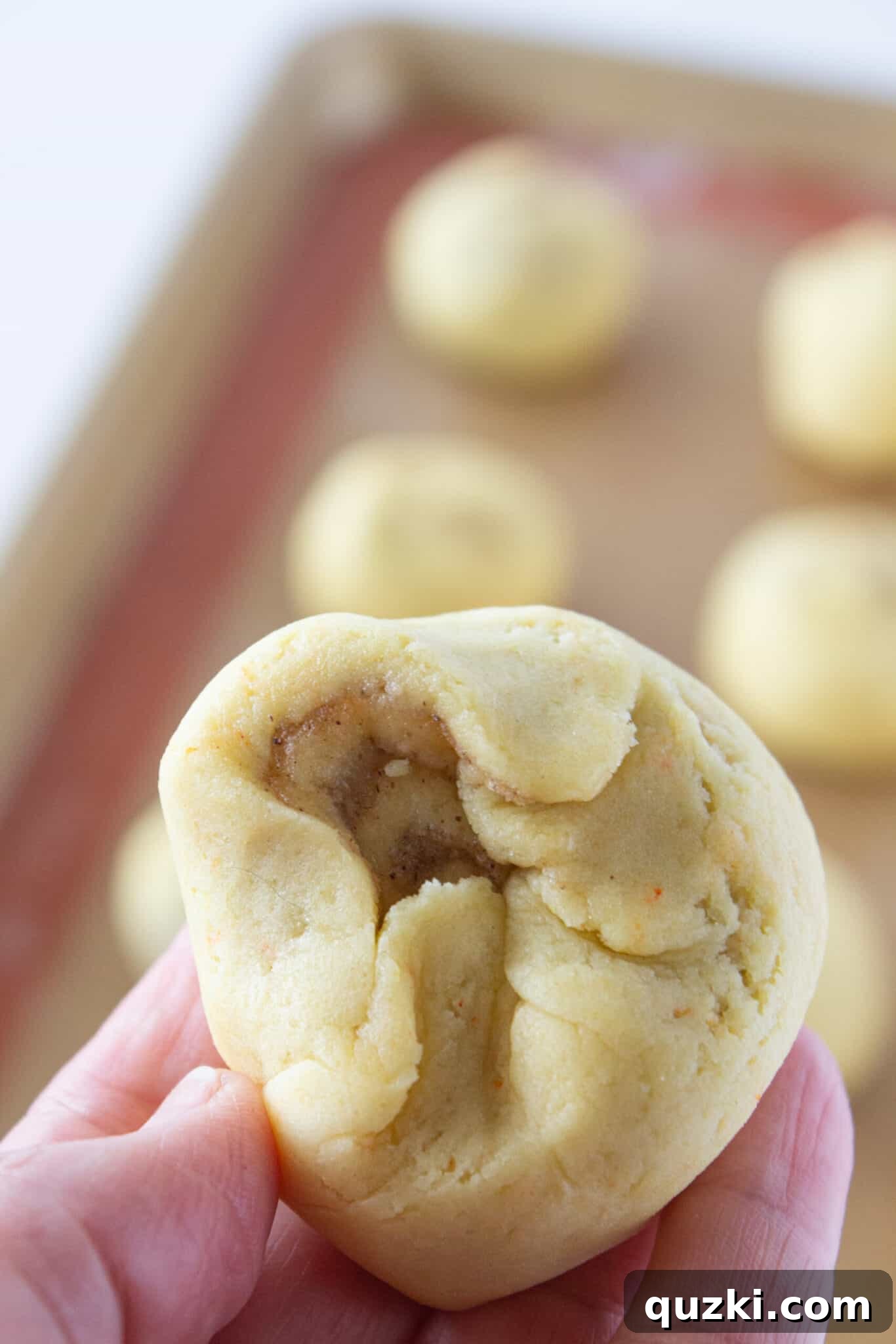 Cinnamon roll cookie dough slices with edges pinched to seal filling