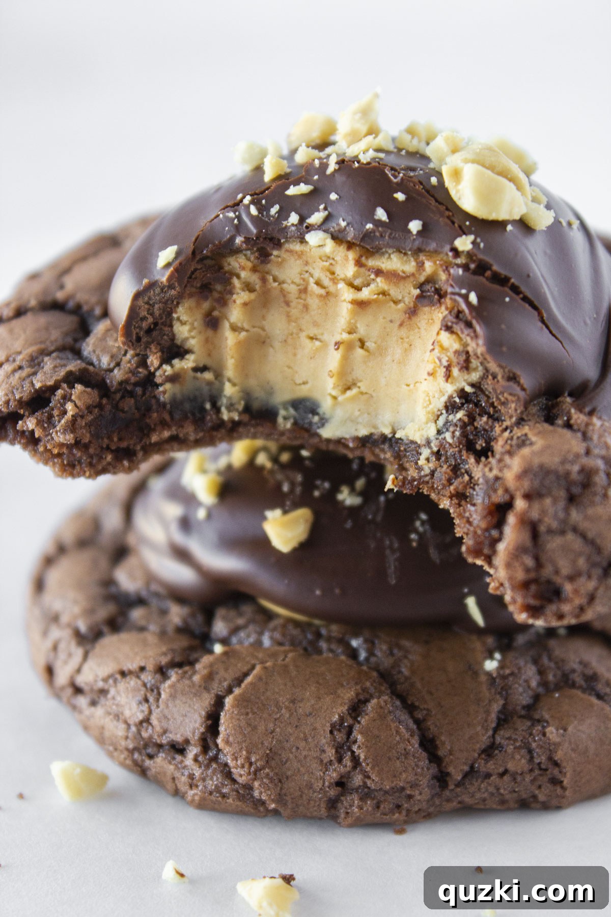 Simple Buckeye Brownie Indulgence 2 Two Buckeye Brownie Cookies stacked on top of each other with a bite taken out of the top cookie, revealing the peanut butter center. Perfect for chocolate and peanut butter lovers.