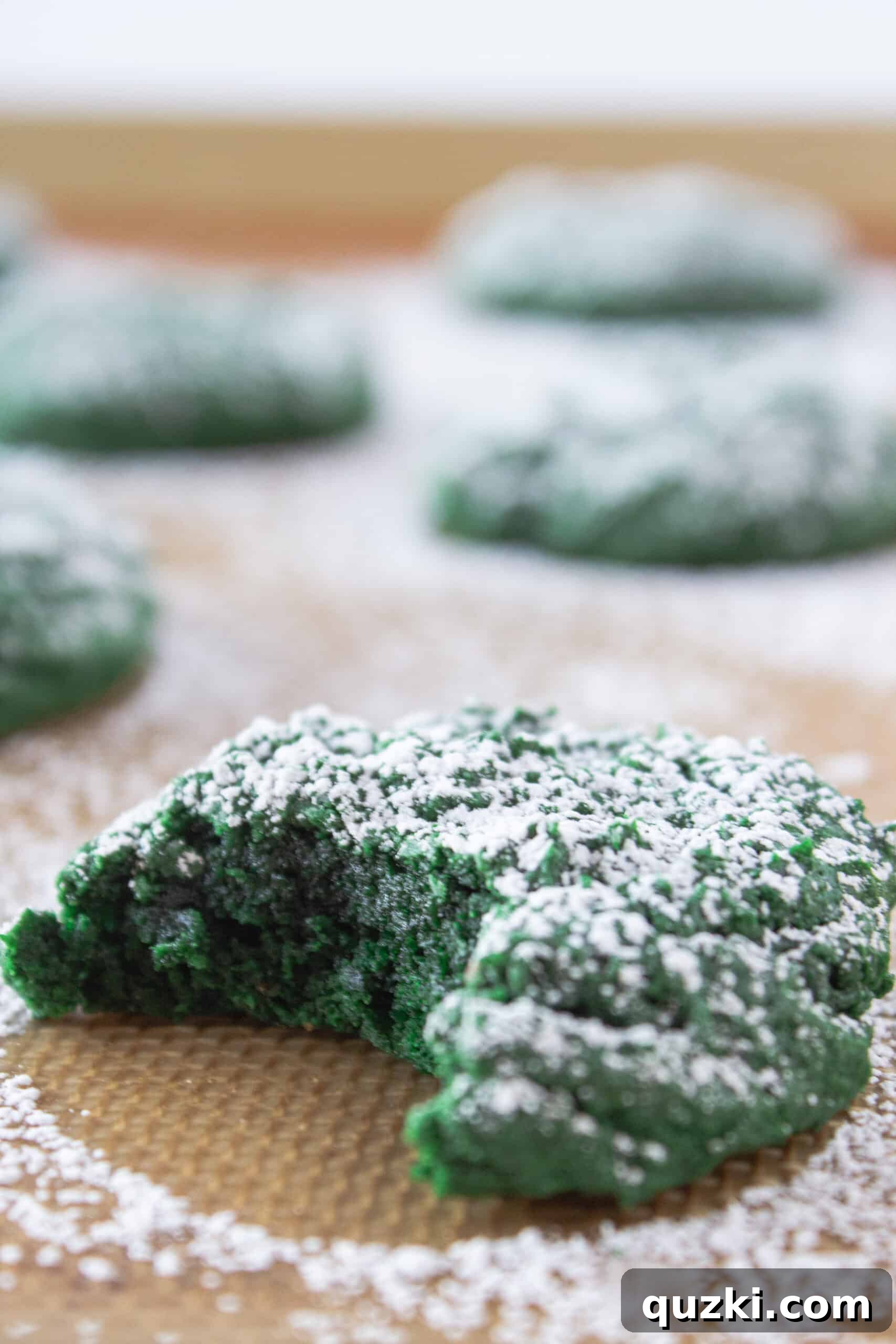 Effortless Green Velvet Cake Mix Cookies 9 A close-up of a broken Green Velvet Cream Cheese Cookie, revealing the soft, chocolatey interior.