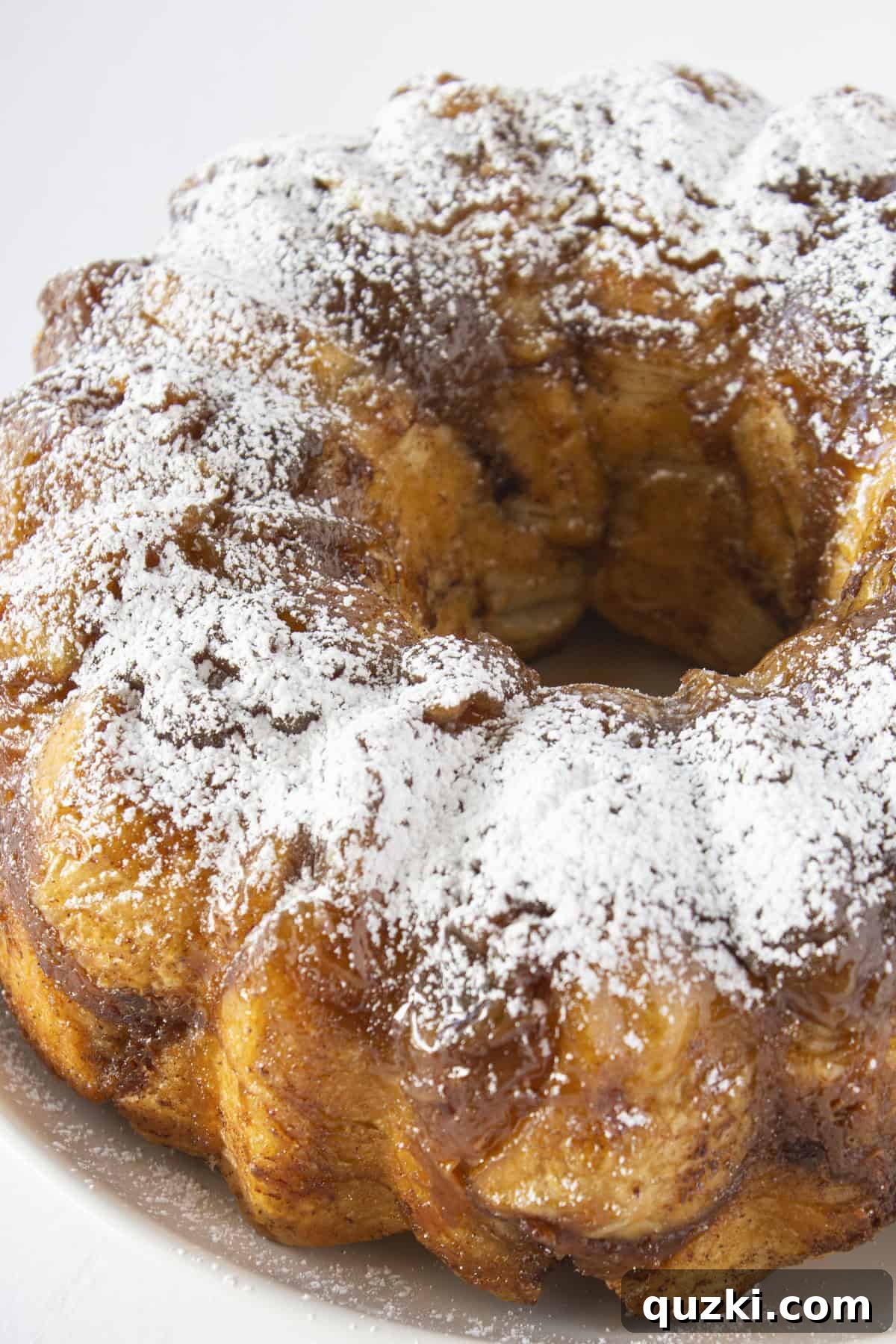 A French toast monkey bread that is baked in a bundt pan and sprinkled with powdered sugar.