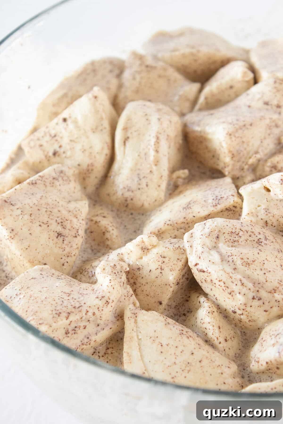 Adding refrigerated biscuits that are cut into quarters into the batter.
