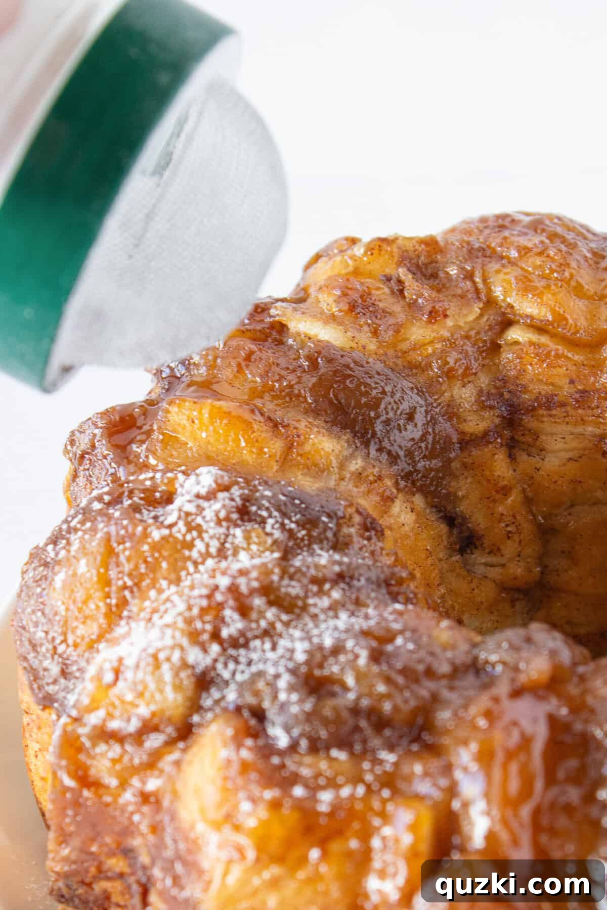 Sprinkling the french toast with powdered sugar before serving.