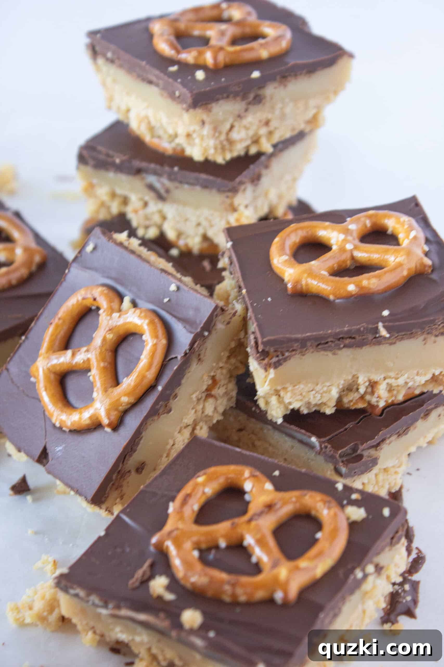 Cutting the finished No Bake Millionaire Bars into squares, guided by the top pretzels