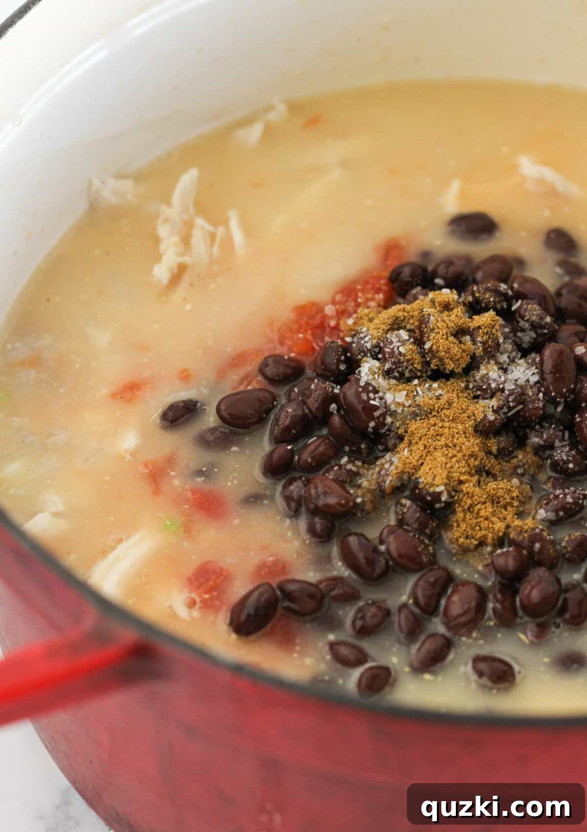 Effortless 20 Minute Chicken Enchilada Soup 6 Adding chicken, enchilada sauce, black beans, Rotel, and spices into the simmering soup base.