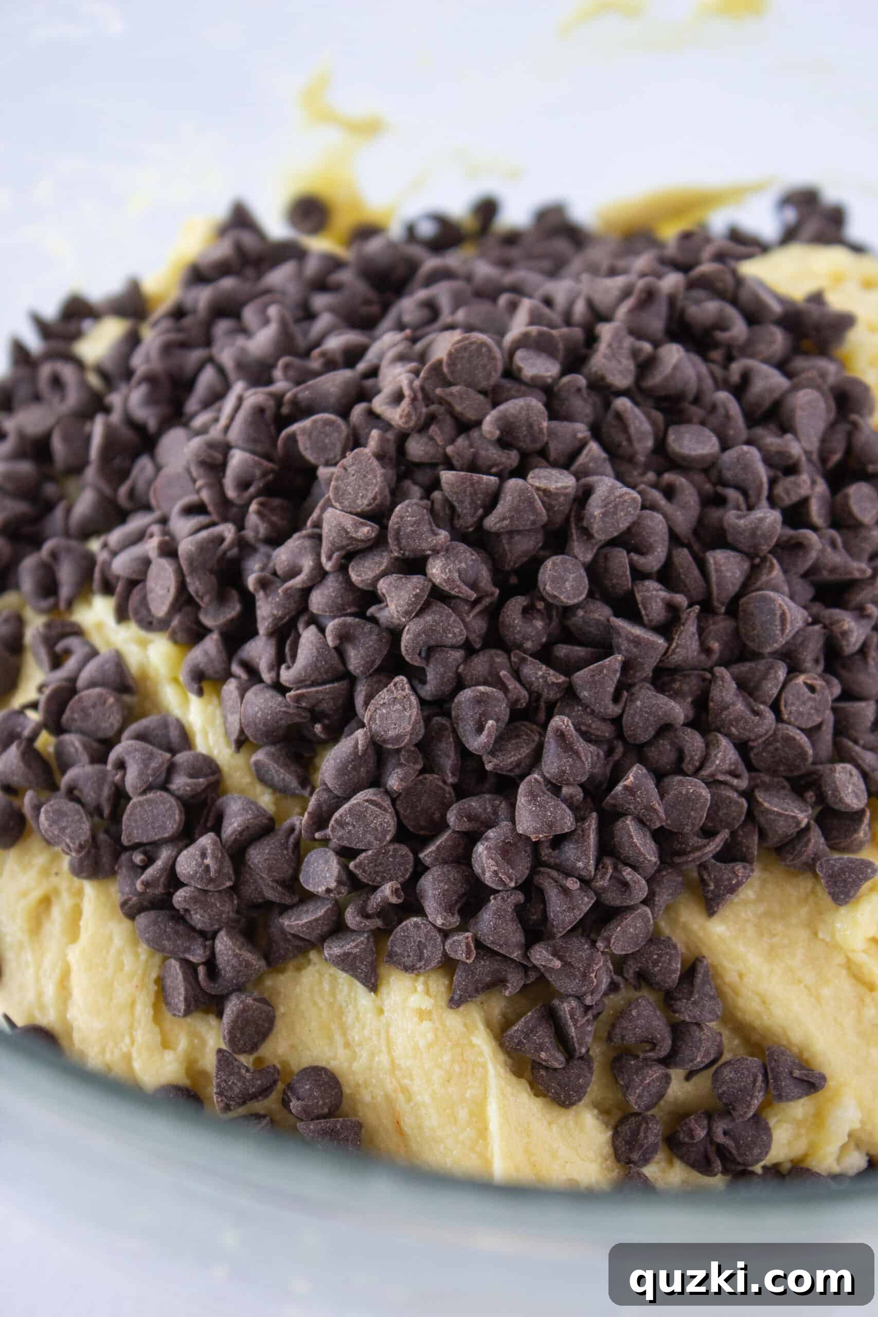 Miniature chocolate chips being folded into the cake mix cookie dough, ready for baking.