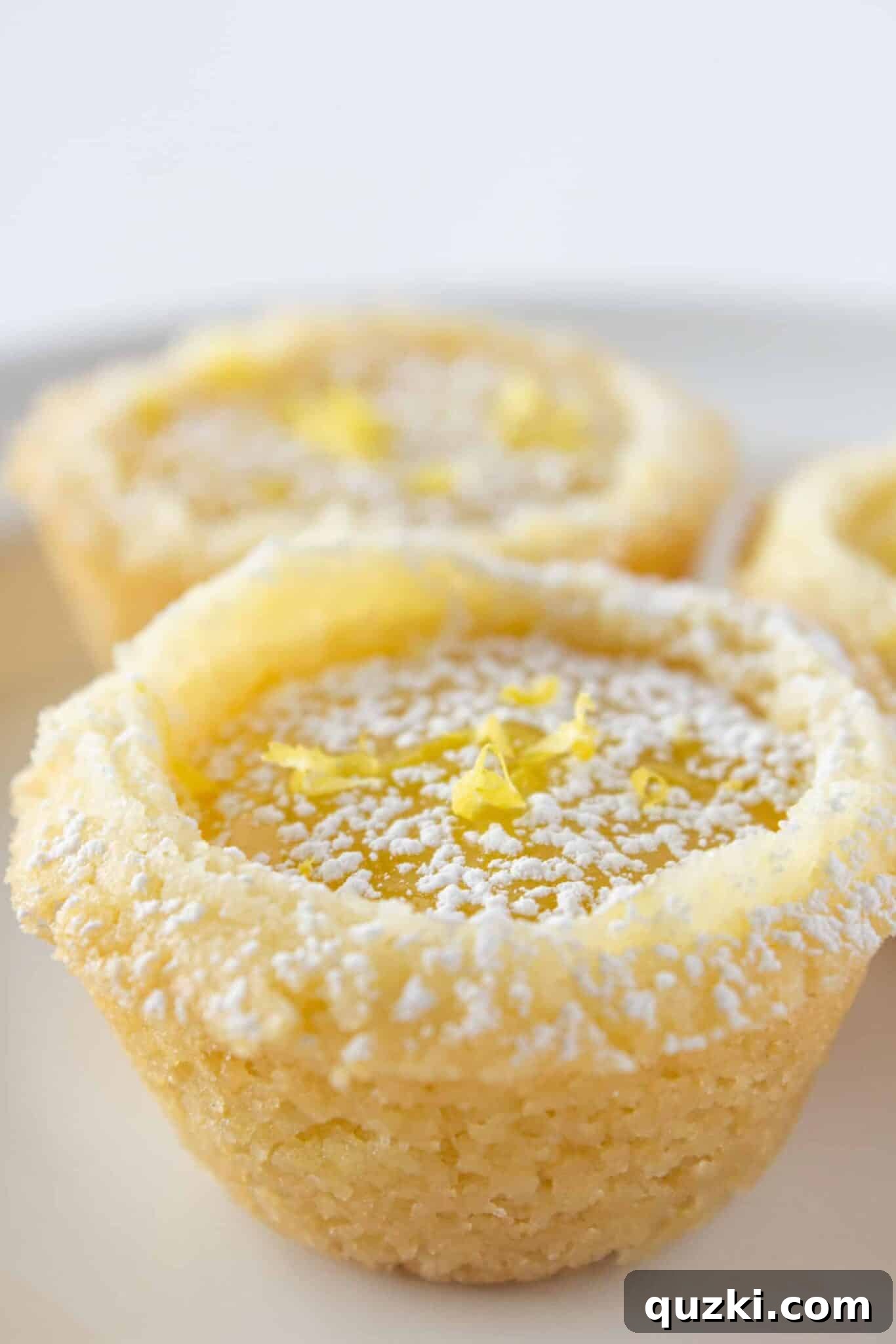 An elegant display of Lemon Bar Cookie Cups arranged on a white serving tray, ready for a gathering or special occasion.