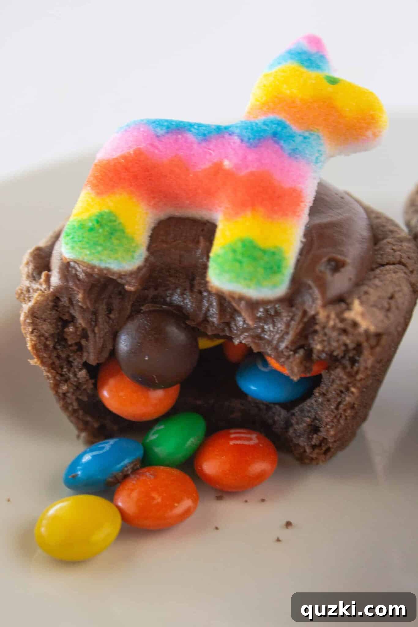 Cake Mix Shortcut Pinata Cookies 12 A single Pinata Cookie with candies playfully spilling out from its center, ready to be eaten.