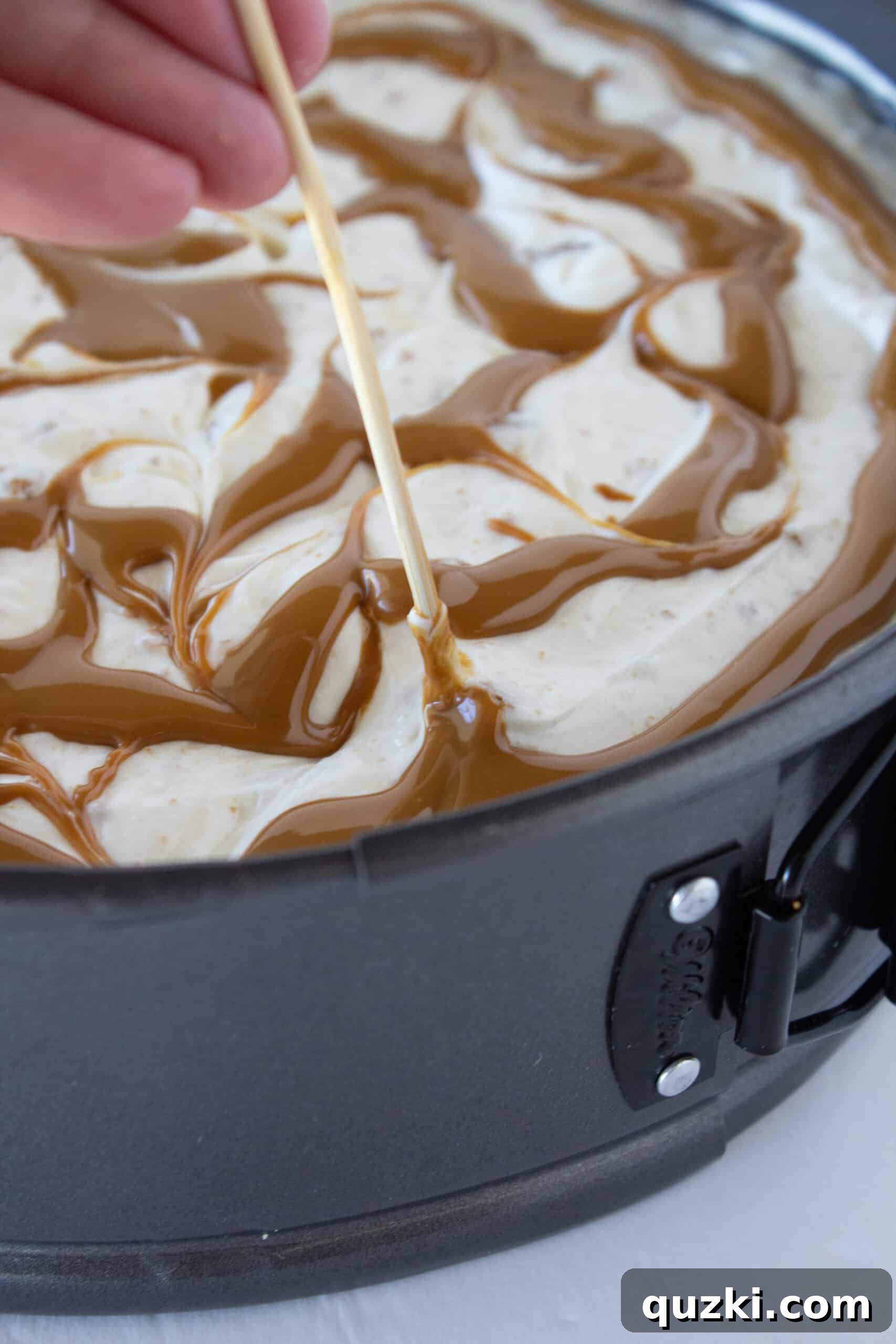 Decadent Cookie Butter No-Bake Cheesecake 11 A toothpick creating a beautiful swirl pattern in the cookie butter topping on the cheesecake